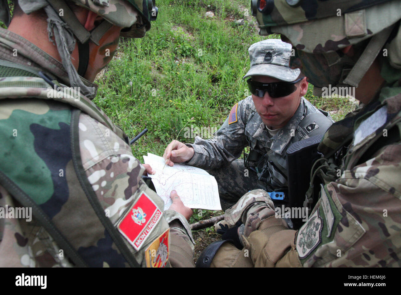 U.S. Army Europe's SFC Randy Angel, one of the observer controllers with the Joint Multi-national Training Command out of Hohenfels, Germany from St. Louis, MO uses a map to give guidance to members of the Montenegrin Army as they conduct an ambush exercise during the Immediate Response 2012 (IR12) training event held in Slunj, Croatia on Friday, June 1, 2012.  IR12 is a multinational tactical field training exercise that will involve more than 700 personnel primarily from the U.S. Army Europeís 2nd Calvary Regiment and Croatian armed forces, with contingents from Albania, Bosnia-Herzegovina,  Stock Photo
