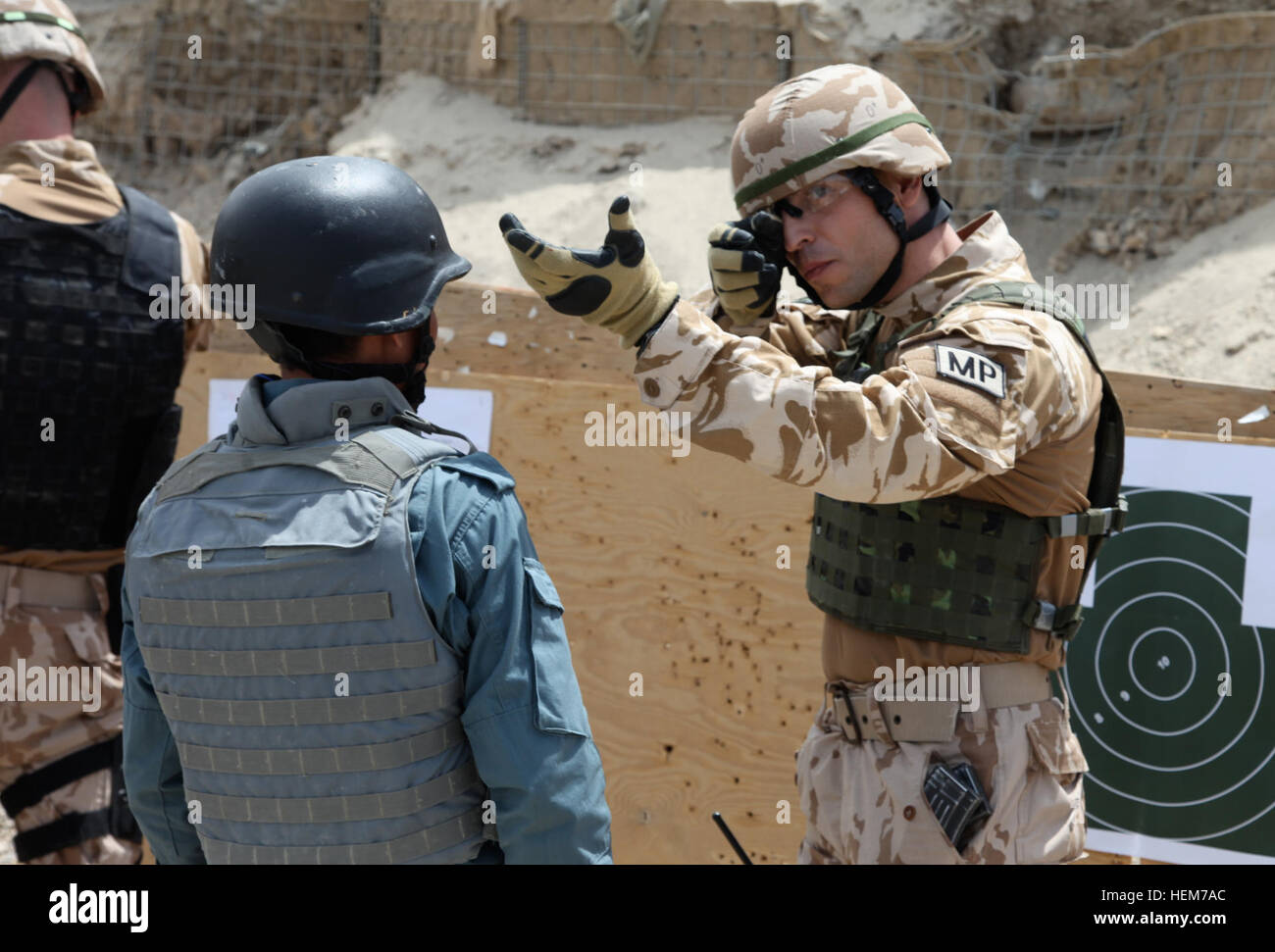 A Czech Military Police officer is demonstrating how to maintain a good sight picture to an Afghan Uniform Police Recruit after firing the AK-47 assault rifle at the Swanson Firing Range, Forward Operating Base Shank, Logar province, Afghanistan, June 18, 2012. AUP recruits firing range 120618-A-BZ540-005 Stock Photo