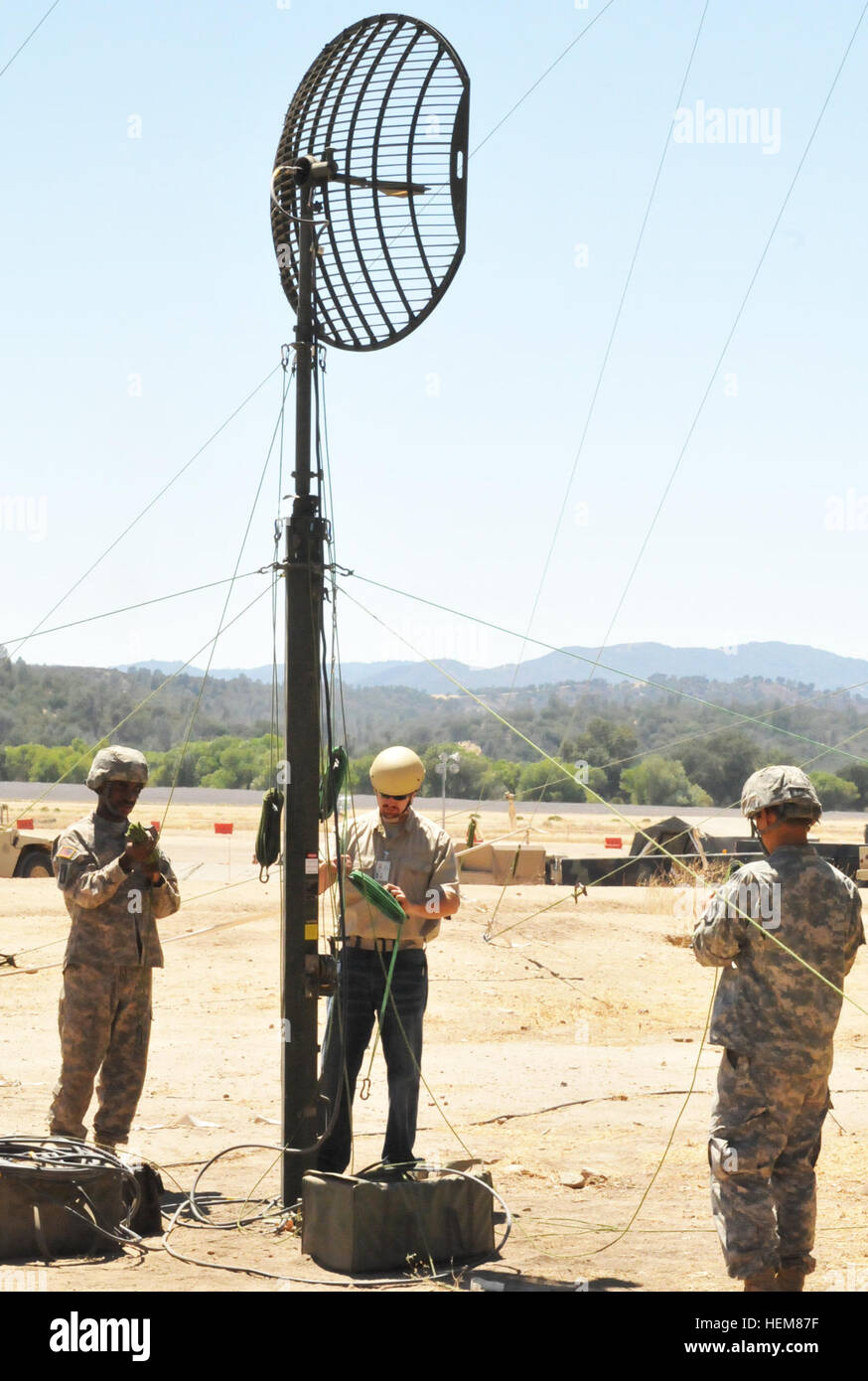 Spc. Cedric Alston (left) and Pfc. William Kim, 392nd Expeditionary Signal Battalion soldiers, help Bradley Baldwin, a Department of the Army logistics assistant representative, dismantle a high-capacity line-of-sight antenna during Exercise Grecian Firebolt at Fort Hunter Liggett, Calif. Grecian Firebolt 2012 640897 Stock Photo