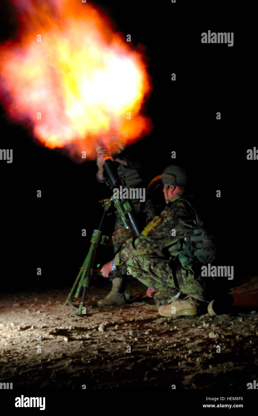 Afghan National Army soldiers with the Heavy Weapons Platoon, 6th Kandak, brace as an illumination round fires from an 82mm mortar tube during the night validation portion of the mortar course held at Patrol Base Sorkh Bid, Afghanistan, July 28, 2012. The class was taught by members of Mentor Team Bravo 3rd Royal Australian Regiment. Australian soldiers train Afghan Heavy Weapons Platoon on mortar course 120728-A-GM826-451 Stock Photo
