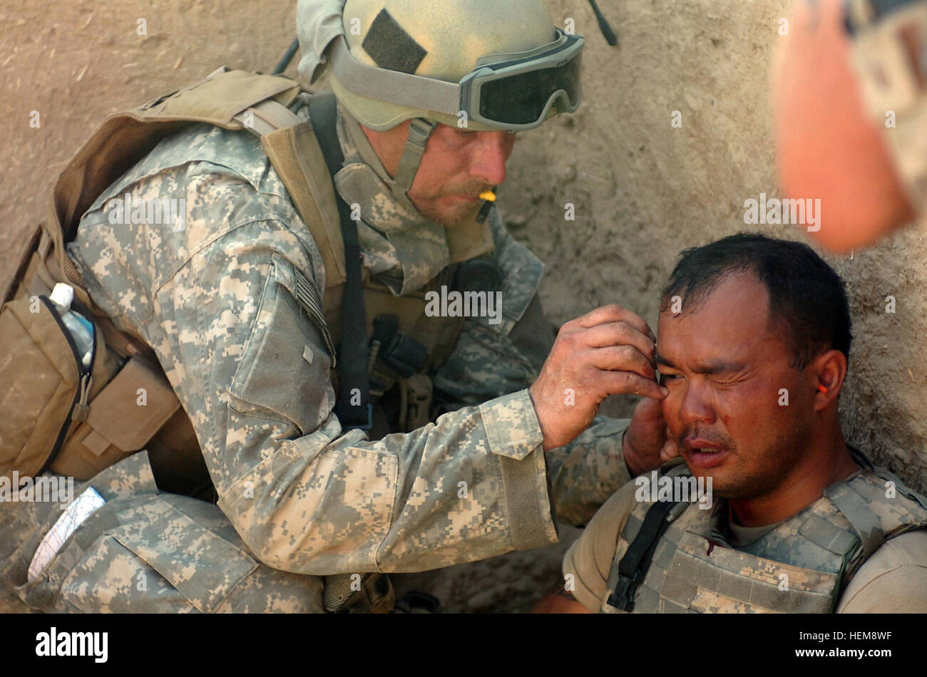 A Special Forces team medic assigned to the Combined Joint Special Operations Task Force- Afghanistan treats another U.S. Army Soldier for shrapnel wounds from a rocket-propelled grenade explosion while battling Taliban fighters in the Sangin District area of Helmand Province, Afghanistan, April 10, 2007. The Soldier continued fighting minutes after he was treated. (U.S. Army photo by Spc. Daniel Love) (Released) US injured soldier Stock Photo