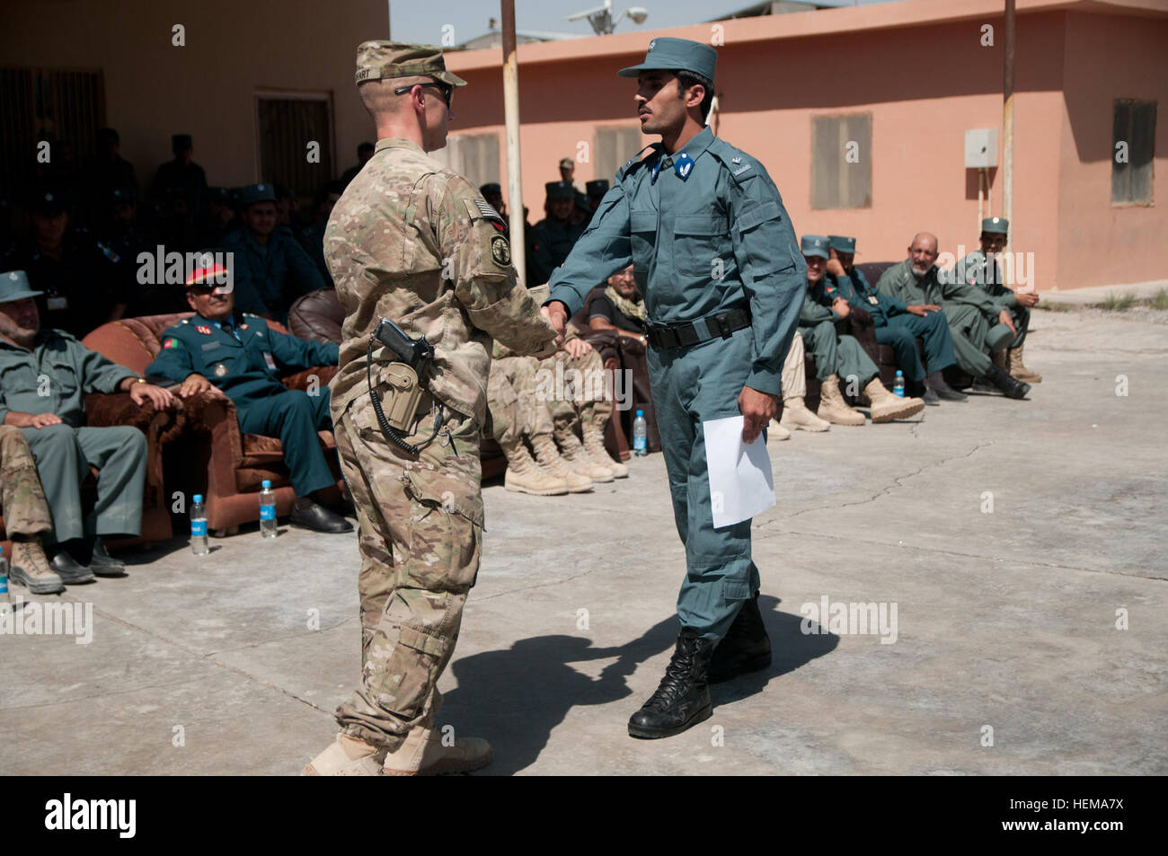 Lt. Col. Terry Nihart, commander of Task Force Ripcord, 503rd Military  Police Battalion (Airborne), congratulates an Afghan National Police  officer graduate after awarding him his certificate at a graduation  ceremony Sept. 20,