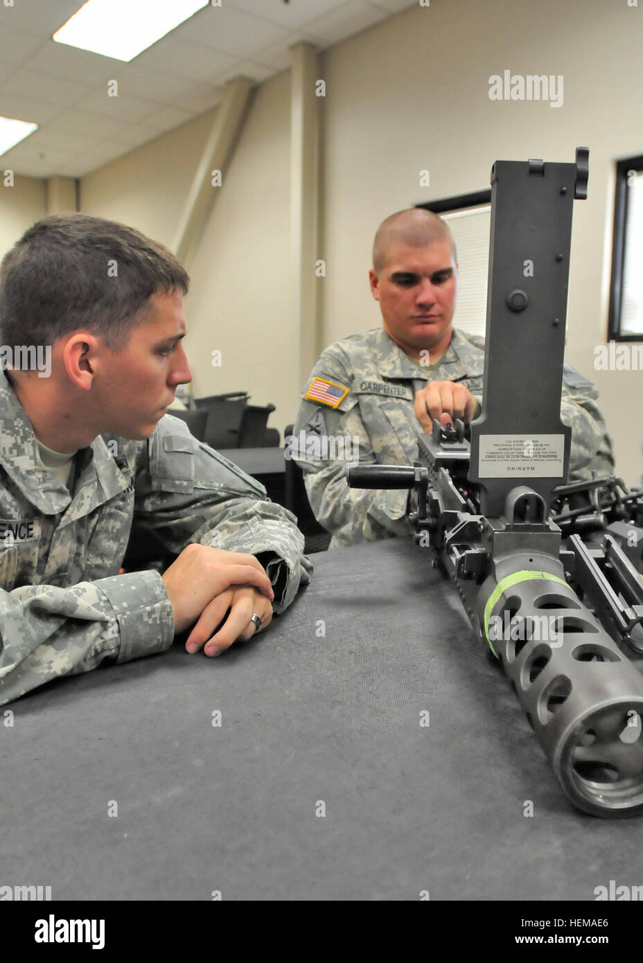 U.S. Army Sgt. Todd Lawrence, (left), a native of Las Cruces, N.M., and infantryman assigned to Company A, 1st Battalion, 77th Infantry Regiment, 4th Heavy Brigade Combat Team, 1st Armored Division, watches as Spc. Zachary Carpenter, a native of Callisburg, Texas, and infantryman assigned to 5th Infantry Regiment, 2nd Battalion, 3rd Infantry Brigade Combat Team, 1st Armored Division, both based out of Fort Bliss, Texas, practices taking apart an M2 heavy machine gun. Service members who attend the unit armorer course held at the troop school on Biggs Army Airfield are taught how to properly ma Stock Photo