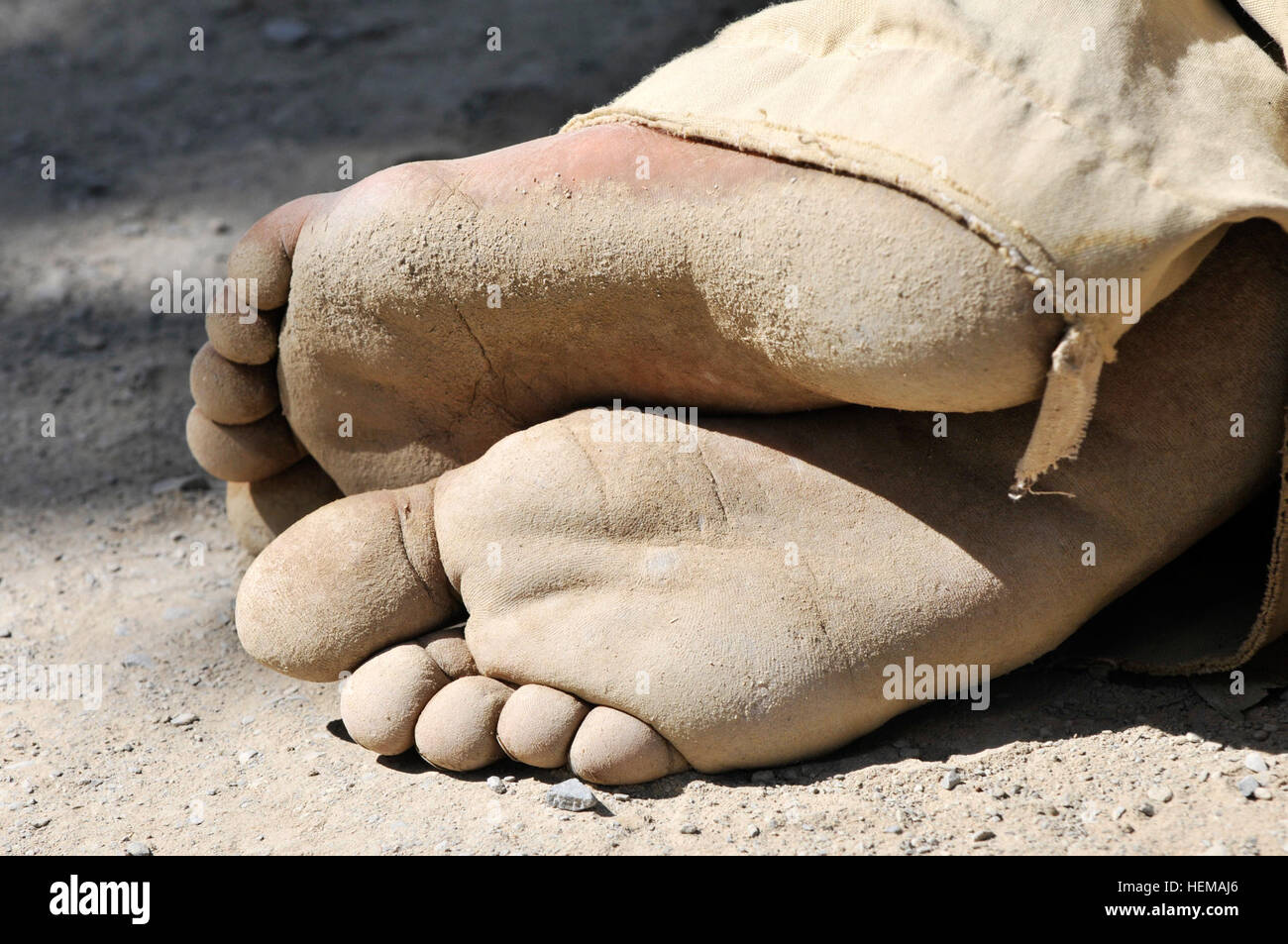 Dust covers the feet of an Afghan boy in the village of Obezhan Kalay in the Spin Boldak district Afghanistan Sept. 30 2012. The youth was listening while village elders participated in