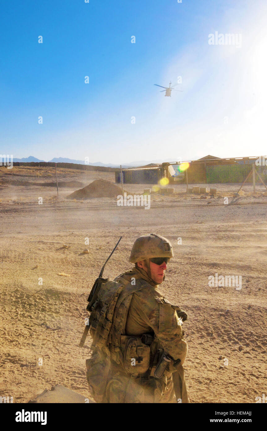 An Australian Army soldier pulls security of the landing zone while a UH-60 Blackhawk helicopter departs with a wounded soldier during a Medevac training mission held at Multinational Base Tarin Kot, Afghanistan, Oct. 1, 2012. Angels of mercy, Forward Support Medical Platoon 3 saves lives in Uruzgan 121001-A-GM826-161 Stock Photo