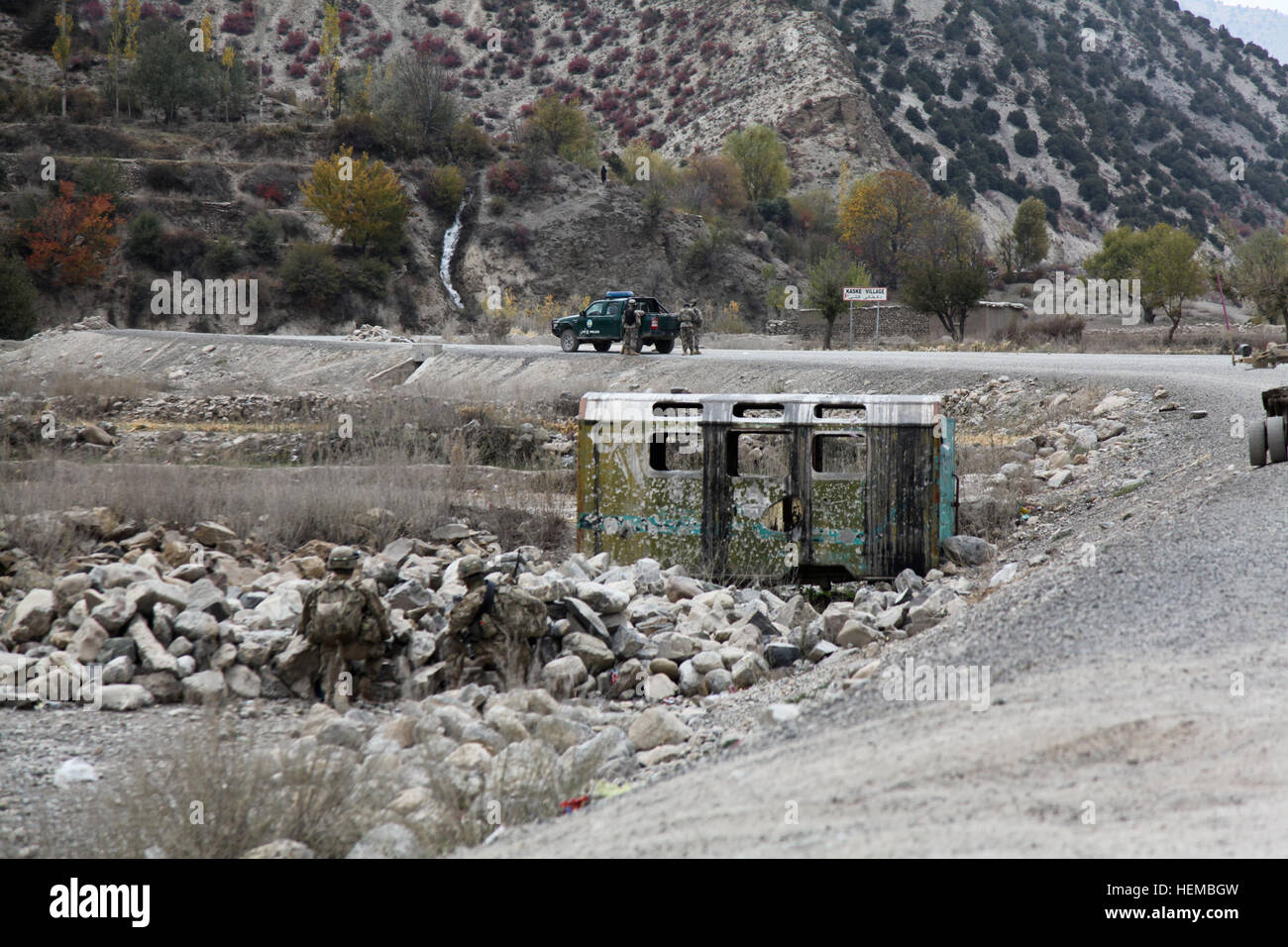 Afghan Border Police officers stand by their truck parked by the entrance to Kaske village in Paktia province, Afghanistan, Oct. 31, 2012. The ABP were assisting the U.S. soldiers with security during a visit to the village. (U.S. Army photo by Spc. Jenny Lui/Released) Kaske village visit 121031-A-TT389-011 Stock Photo