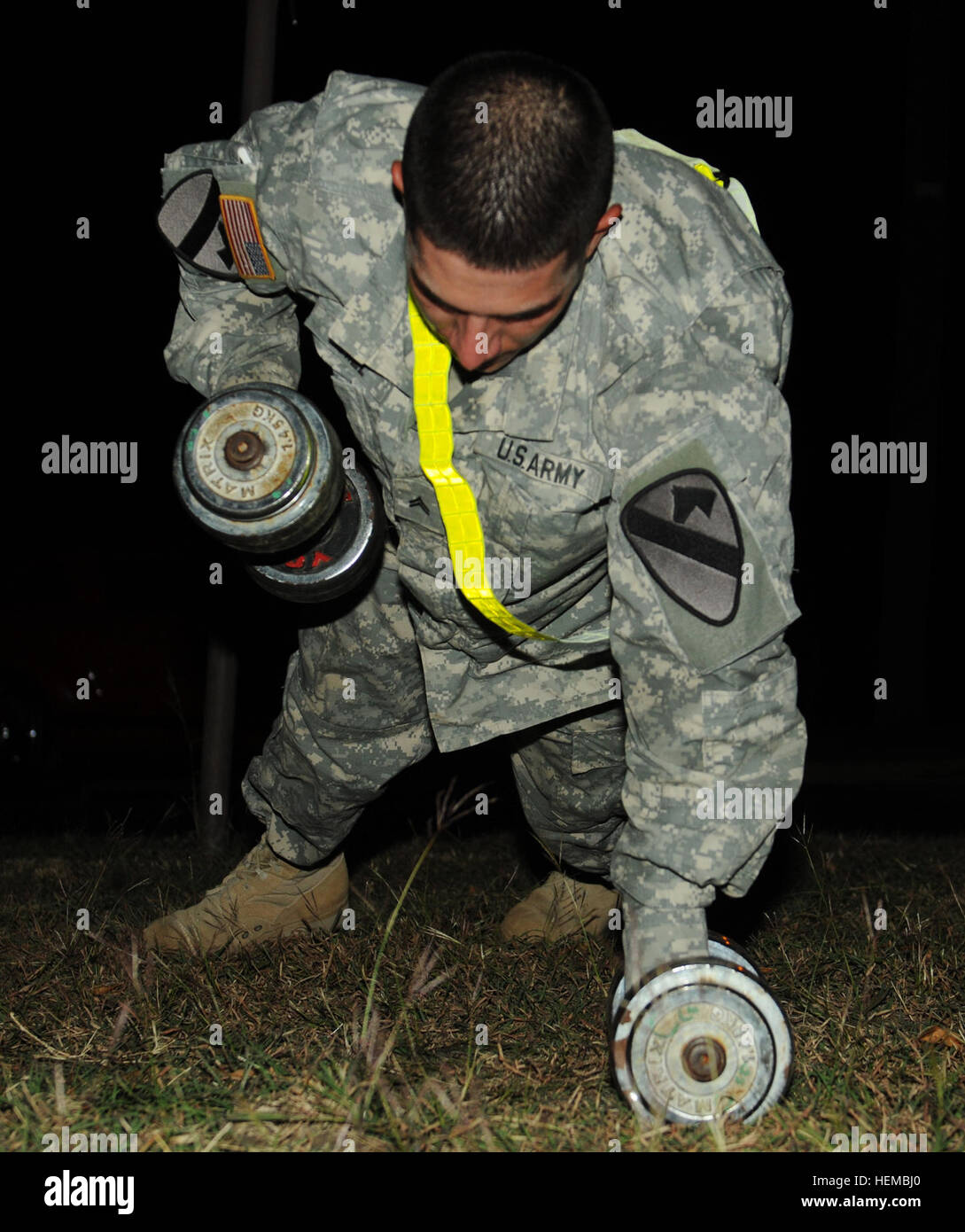 Cpl. Casey Hill, a cavalry scout with Troop B., 4-9 Cav. 'Dark Horse' 2nd BCT, 1st Cav. Div., performs a modified pushup utilizing dumbbells during the 3.2-mile, round robin Dark Horse Noncommissioned Officer Physical Fitness Challenge here, Nov. 2.   (Photo by Sgt. Quentin Johnson, 2BCT, 1st Cav Div PAO) Soldiers take part in battalion-wide PT challenge 121102-A-CJ112-621 Stock Photo