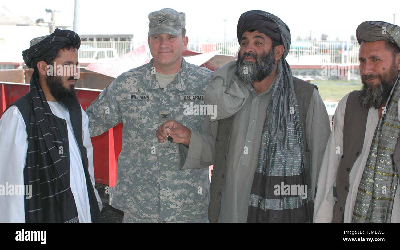 U.S. Army Col. R. Stephen Williams, the commander of the 207th Infantry Brigade, stands with local leaders in the Kandahar province of Afghanistan May 15, 2007, as they accept the keys to the 64th tractor distributed as part of Task Force Grizzly's farm implement donation project to support farmers in the local area. (U.S. Army photo by Capt. Vanessa R. Bowman) (Released) US Army with local leaders of Kandahar Province Stock Photo