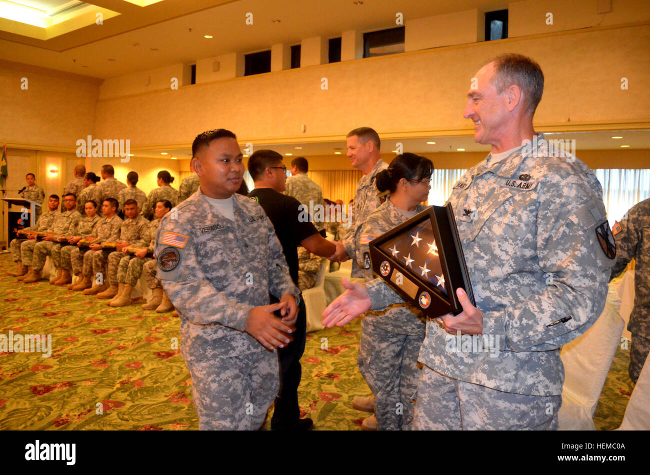 Col. Randy Hart, commander, 303rd Maneuver Enhancement Brigade, presents a boxed flag to Sgt. Joel Verango during a Welcome Home Warrior-Citizen ceremony conducted at the Guam Marriott Resort & Spa, Nov. 11. More than 60 members of the 368th Military Police Company returned to Guam after a 12-month deployment to Kuwait and Qatar in support of Operation Enduring Freedom. 9th MSC Guam MPs welcomed home following recent deployment 787244 Stock Photo