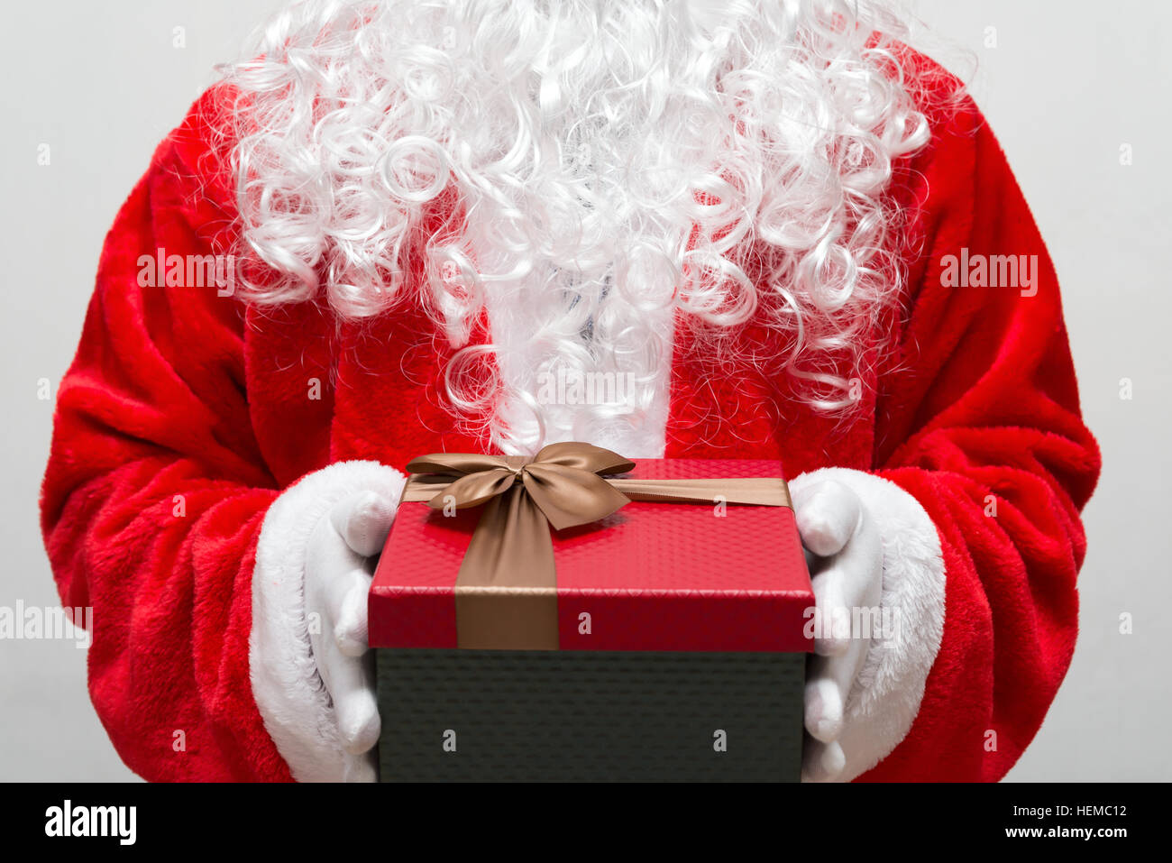 Santa Claus handing a gift box Stock Photo - Alamy