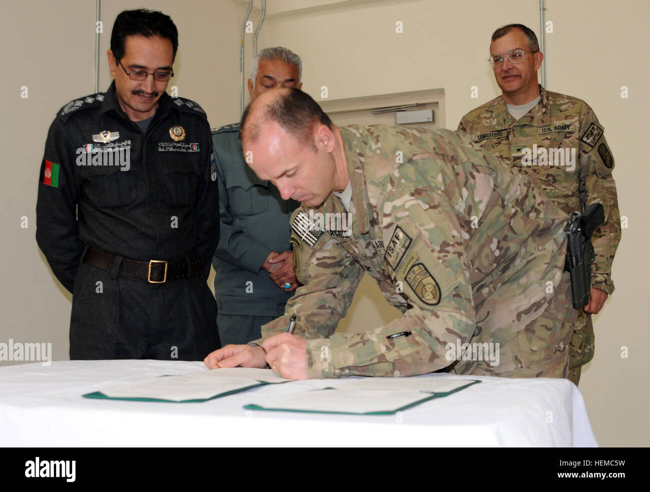 US Army Col. Andy Backus, the NATO Training Mission-Afghanistan engineer director, signs documents transitioning the Wardak National Logistics Center to the Afghan National Police Nov. 18, 2012, during a ribbon-cutting ceremony. Backus was actively involved in overseeing the construction project. The new facility allows several ANA logistics entities to work out of the same location instead of various locations scattered through the capital, Kabul. (Photo by U.S. Army Capt. Monika Comeaux, NTM-A/DCOM-SPO PAO) National Logistics Center-Wardak transitions to Afghan National Police control 121118 Stock Photo