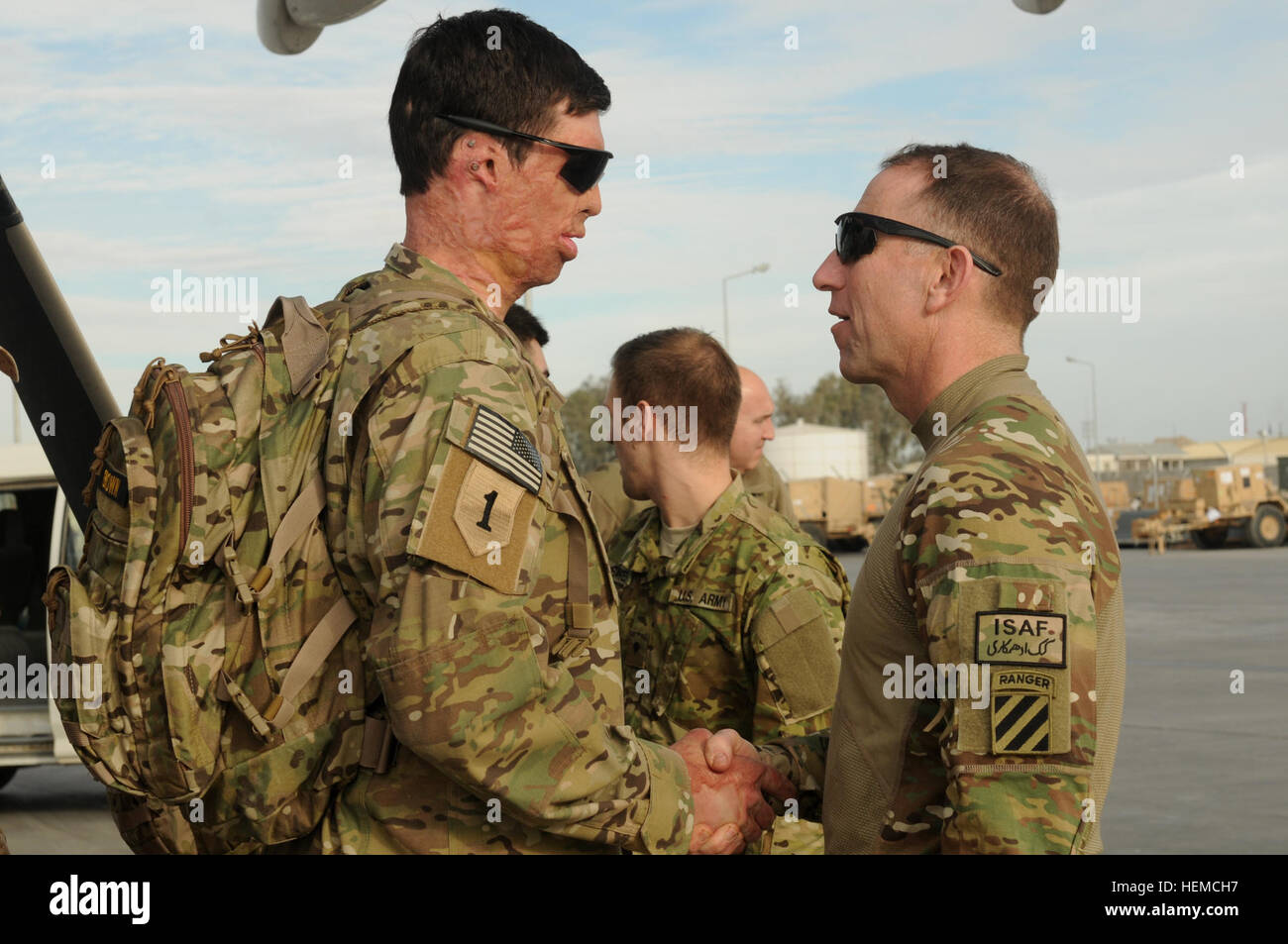 Retired Army Capt. Samuel Brown shakes hands with Maj. Gen. Robert 'Abe' Abrams, 3rd Infantry Division and Regional Command (South) commanding general, upon arrival at Kandahar Airfield, Afghanistan, for Operation Proper Exit, Dec. 6, 2012. Operation Proper Exit brings severely wounded service members back to the theater where they sustained their injuries to provide a firsthand progress update on the continuing mission and to help in the healing process. Brown is from Dallas, Texas. (U.S. Army photo by Sgt. Ashley Curtis) Wounded Warriors return to Afghanistan, believe 'It was all for somethi Stock Photo