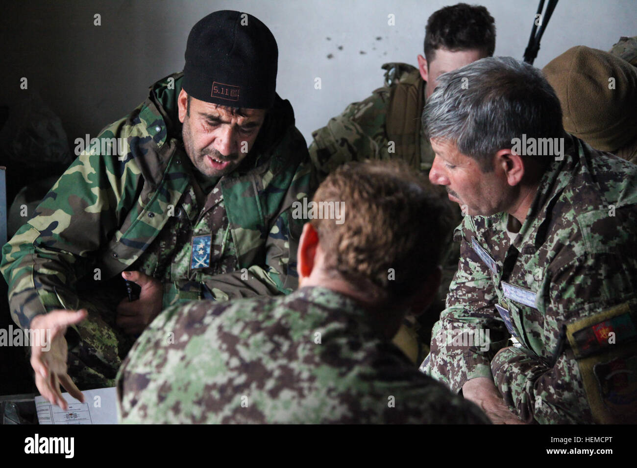Afghan National Army (ANA) Lt. Col. Omar Gul with the 2nd Kandak, 4th Brigade, 201st Corps, speaks with other ANA officers about a clearing operation while looking at a map in a temporary ANA tactical operations center in Bati Kot, Nangarhar province, Afghanistan, Dec. 13, 2012. The ANA were conducting the clearing operation to deny insurgents the freedom of movement and to secure a local highway. (U.S. Army photo by Spc. Jenny Lui/Released) SFAAT Advise and Assist in Sector 121213-A-TT389-146 Stock Photo