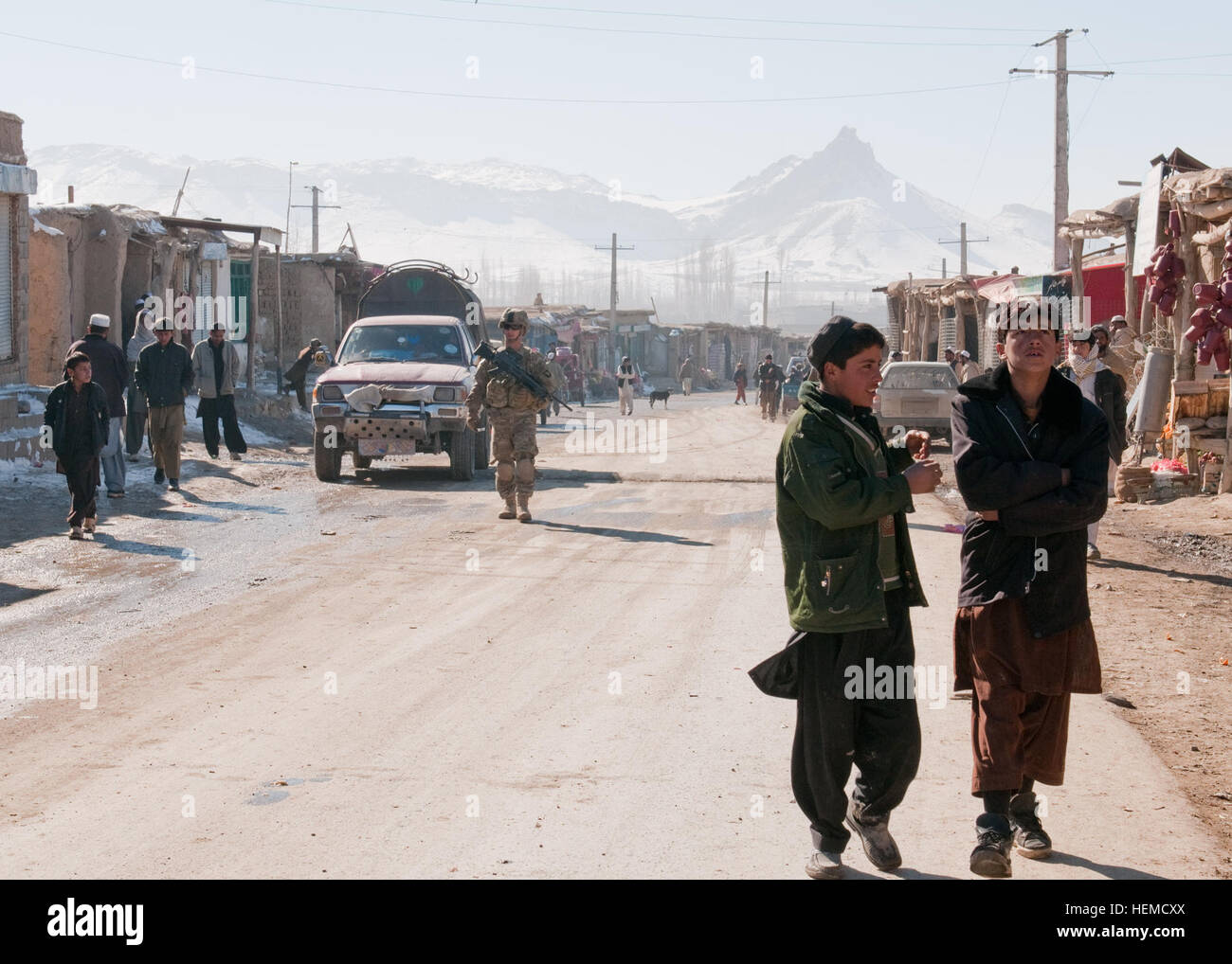 Two Afghan boys walk ahead of the security forces element of Provincial Reconstruction Team Paktiya in the Sayed Karem District market, Afghanistan, Dec. 20, 2012. PRT Paktiya conducted a market walk to assess the agricultural development of the area and talk to local vendors and farmers. (U.S. Army photo by Sgt. Christopher Bonebrake, 115th Mobile Public Affairs Detachment) Security force platoon helps secure Afghan future 121220-A-GH622-114 Stock Photo