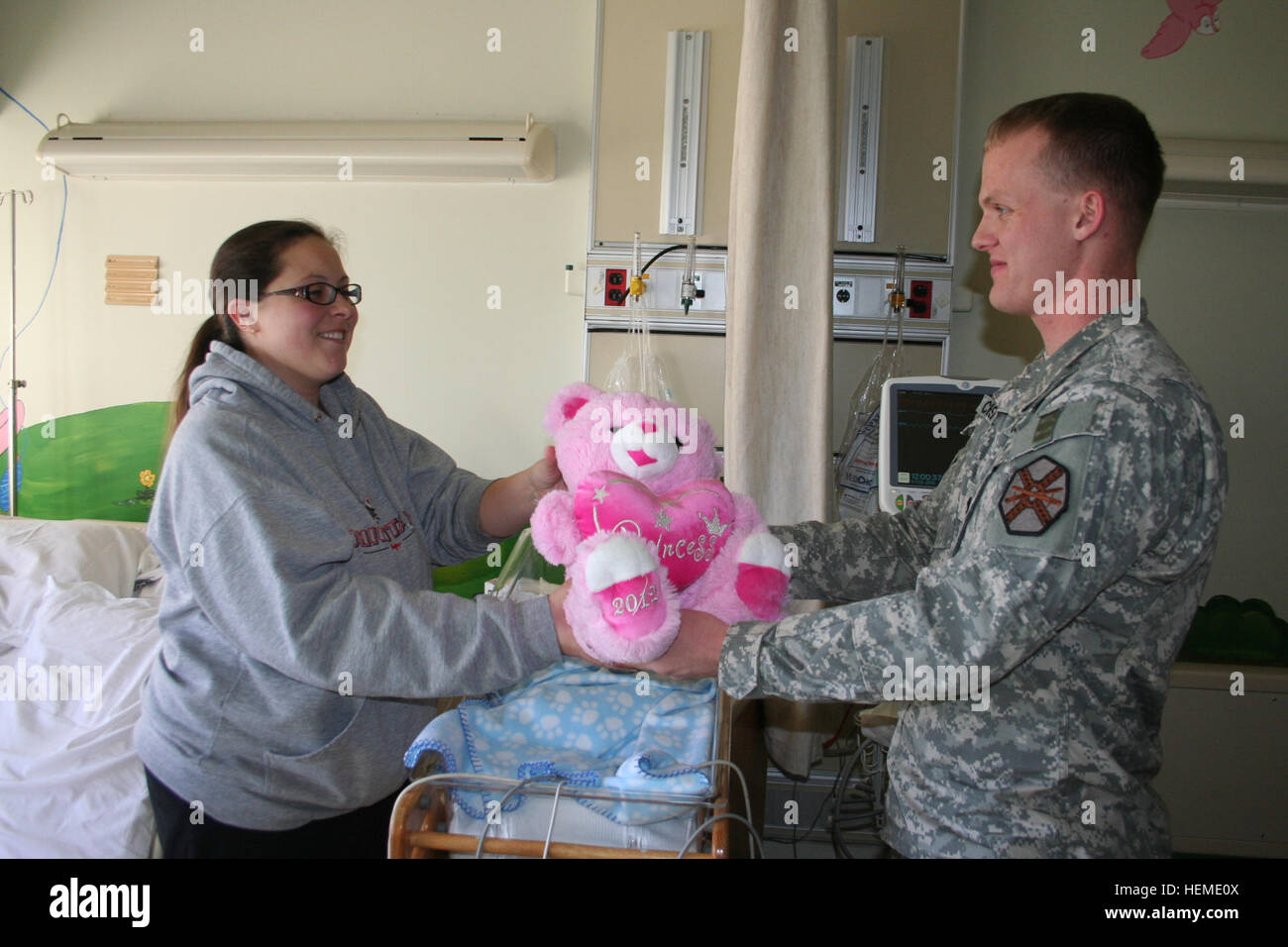 Fort Campbell Better Opportunities for Soldiers (BOSS) President Spc. Lance Christie handed a pink teddy bear Feb. 1 to Stacey Burkepile. Stacey, who has four children, is staying with her 11-day-old son, Walker, while he is receiving care at Blanchfield Army Community Hospital. Walker's old sister, 4-year-old Cadence, keeps her mom and brother company was given a pink teddy bear while her baby brother received a small Valentine's Day bear. Fort Campbell BOSS program donates teddy bears to BACH patients 825226 Stock Photo
