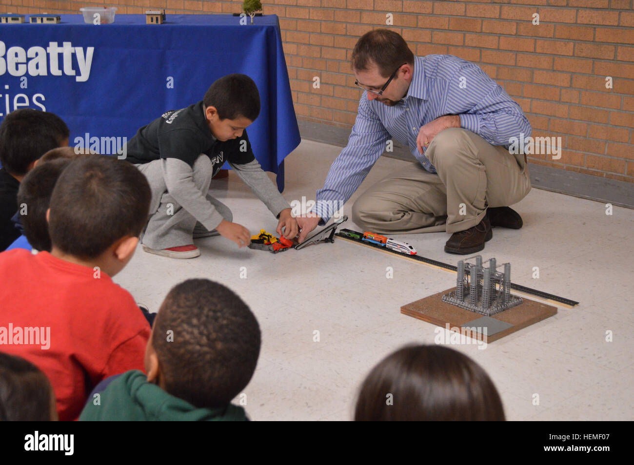 Angel Hurtado, a first grader at Logan Elementary School and Mason Crawford, a volunteer science teacher, participate in an interactive energy demonstration first graders at Logan Elementary School, Feb. 25 highlighting Balfour Beatty Communities' solar energy project scheduled for military housing units here. The school event taught pluses and minuses of energy practices and highlighted the need for sustainable energy sources. BBC and Fort Bliss have partnered with Solar City to install and maintain solar panels on military housing here that will produce approximately 25 percent of electric e Stock Photo