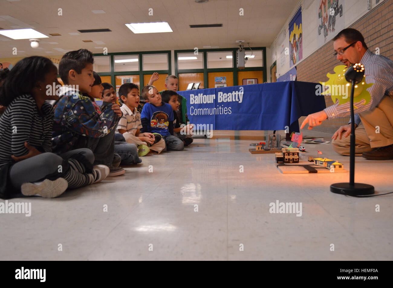 Mason Crawford, a volunteer science teacher, participate in an interactive energy demonstration first graders at Logan Elementary School, Feb. 25 highlighting Balfour Beatty Communities' solar energy project scheduled for military housing units here. The school event taught pluses and minuses of energy practices and highlighted the need for sustainable energy sources. BBC and Fort Bliss have partnered with Solar City to install and maintain solar panels on military housing here that will produce approximately 25 percent of electric energy usage as part of the Army's goal to bring energy sustai Stock Photo