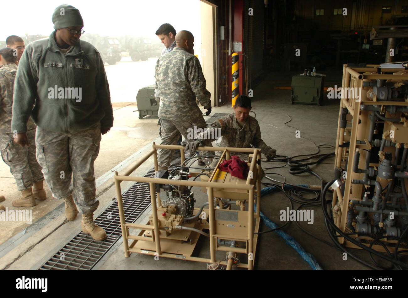 U.S. Army Spc. Justin Degorostiza, center, a water treatment specialist with Alpha Company, 70th Brigade Support Battalion, 210th Fires Brigade, 2nd Infantry Division, performs preventive maintenance checks and services on a lightweight water purifier during training at Camp Casey in Gyeonggi province, South Korea, Feb. 27, 2013.  (U.S. Army photo by Staff Sgt. Carlos Davis/Released) Alpha Distribution Company conducts new equipment training 130227-A-WV398-059 Stock Photo