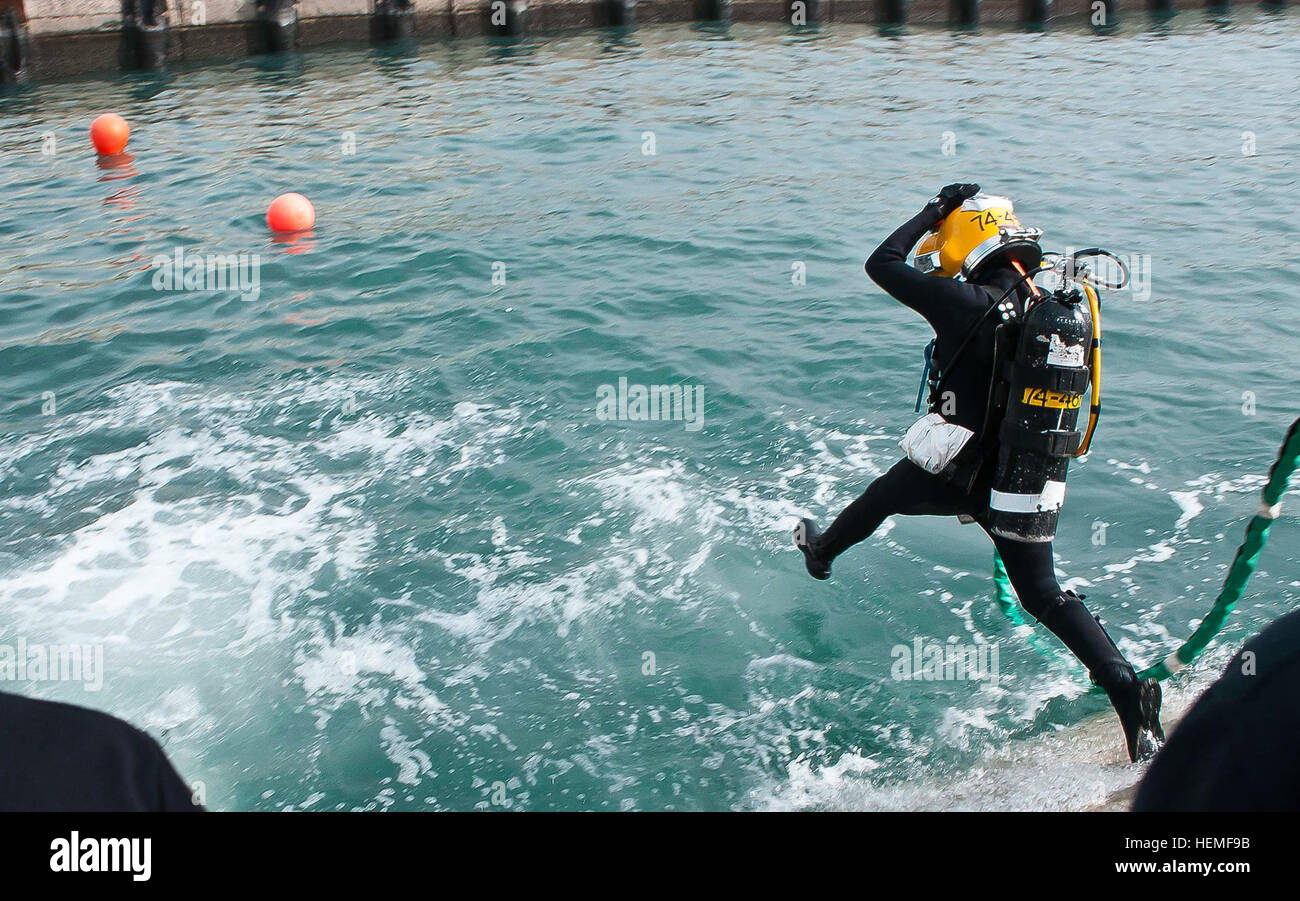 First Lt. Christie Plackis, the fourth female diver in the history of the Army, who serves as the executive officer for the 74th Engineer Dive Detachment and is deployed from Joint Base Langley-Eustis, Va., 'splashes' into the water March 6 at the Sea Point of Debarkation/Embarkation (SPOD), Kuwait. Her detachment participated in an underwater welding and hydraulic-tool training exercise lasting three weeks. (Photo by U.S. Army Sgt. Micah VanDyke, Third Army/ARCENT Public Affairs) Female diver leaves her mark in history 130306-A-KU062-206 Stock Photo