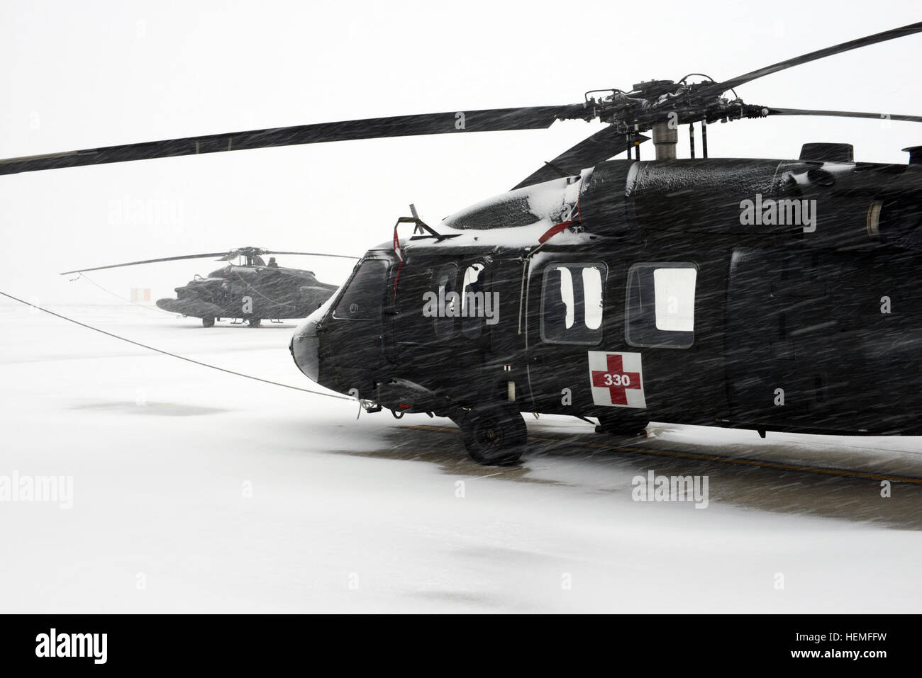 Both of these UH-60 Black Hawks were safe and secure during the blizzard that struck Germany March 12, 2013. (Photo by Dee Crawford, VI Specialist, TSC Wiesbaden) UH-60s in a blizzard 120313-A-Cr252-011 Stock Photo