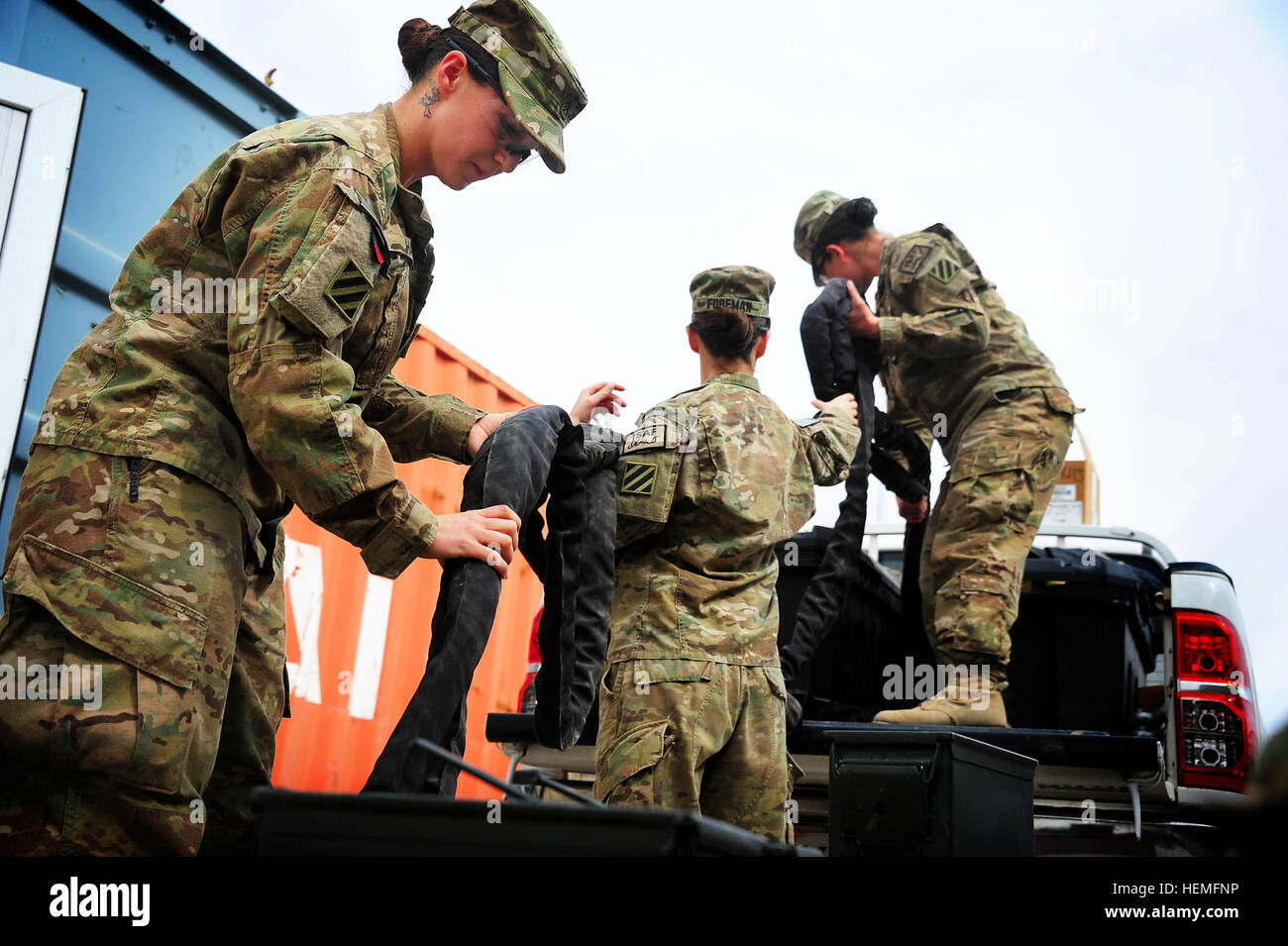 U.S. Army Sgt. Sydney Hays, Specialist Alexandria Foreman, and Sgt. Selvija Bajrami unload gear from a vehicle during an inventory at Multi National Base Tarin Kot, Afghanistan, on Mar. 18, 2013. The three women are stationed at Fort Stewart, Ga., and are assigned to Headquarters and Headquarters Company, 2nd Armored Brigade Combat Team, 3rd Infantry Division. (U.S. Army photo by Sgt. Jessi Ann McCormick) Women serving in Uruzgan province, Afghanistan 130318-A-FS372-733 Stock Photo