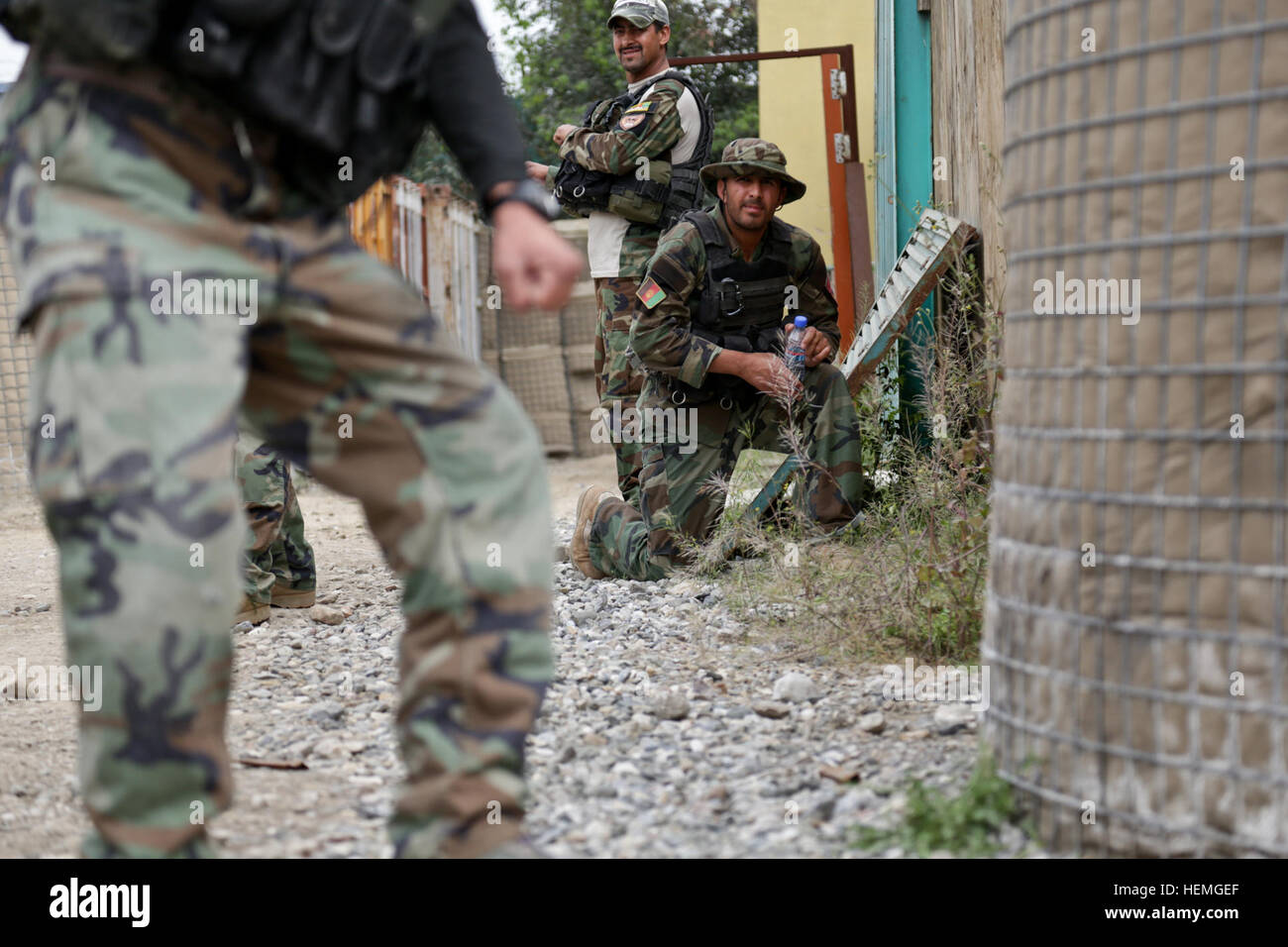 An Afghan National Army commando with 3rd Company, 1st Special Operations Kandak, moves into position as his team prepares to breach a door during training in Behsud district, Nangarhar province, Afghanistan, April 8, 2013. Afghan commandos and coalition forces conducted the training in order to prepare for future operations to disrupt insurgent safe havens and support Afghan Local Police efforts in the area. (U.S. Army photo by Staff Sgt. Kaily Brown/Released) Training in Behsud 130408-A-IS772-078 Stock Photo