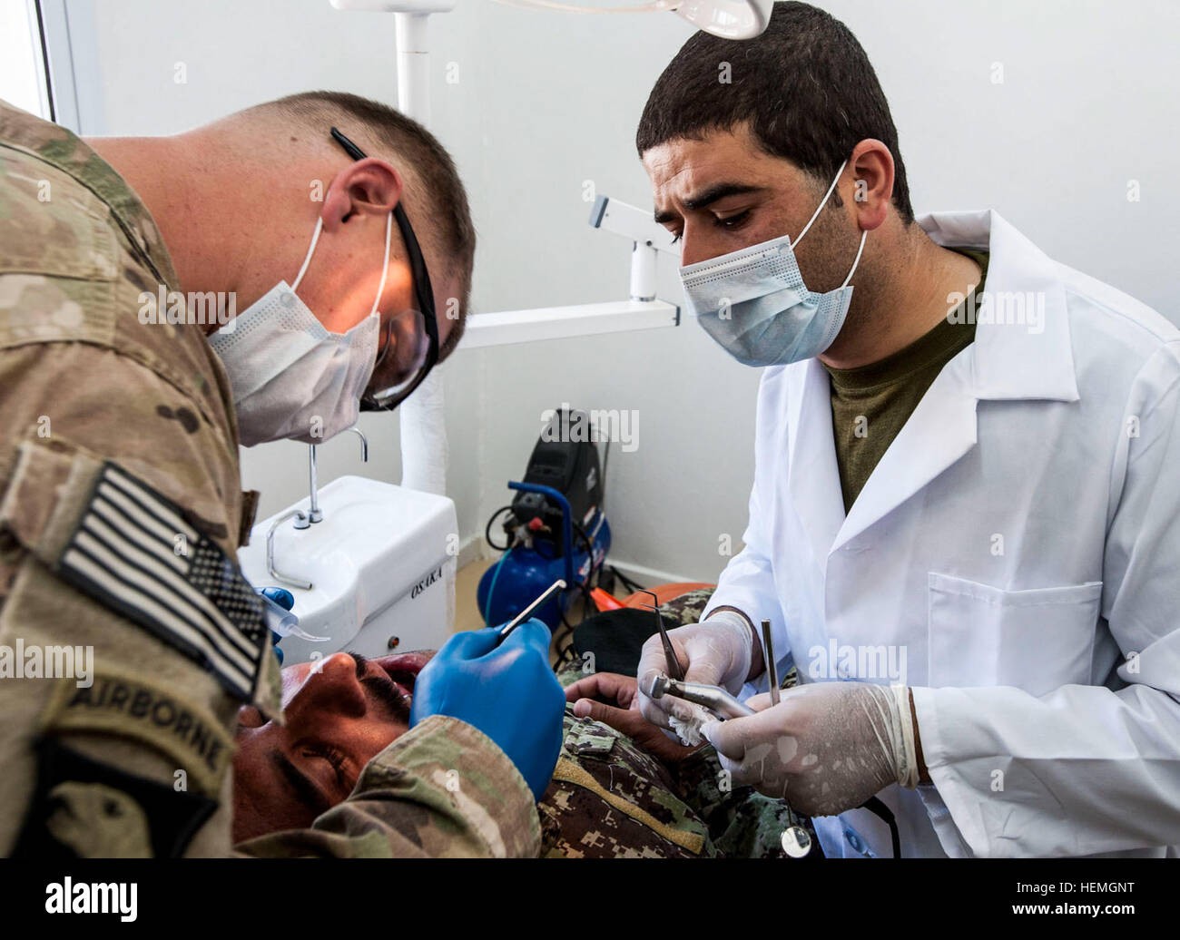 U.S. Army Sgt. Brian Kavanagh, a radiology specialist with Company C, 626th Brigade Support Battalion, 3rd Brigade Combat Team, 101st Airborne Division (Air Assault), inspects a tooth that is in need of extraction, with Afghan National Army (ANA) Dentist Capt. Mirwais Hussaini, 1st Brigade, 203rd Corps, at Camp Pars in Khowst province, Afghanistan, April 14, 2013. The procedure was part of an ongoing partnership between ANA and U.S. Army medical personnel for ANA troops.  (U.S. Army National Guard photo by Sgt. Joshua S. Edwards/Released) Trip to the dentist, How partnership builds a healthier Stock Photo