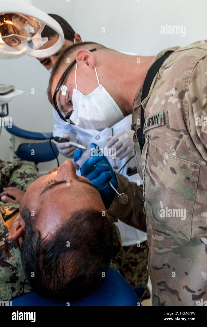 U.S. Army Sgt. Brian Kavanagh, a radiology specialist with Company C, 626th Brigade Support Battalion, 3rd Brigade Combat Team, 101st Airborne Division (Air Assault), inspects a tooth that was drilled for a filling by Afghan National Army (ANA) Dentist Capt. Mirwais Hussaini, 1st Brigade, 203rd Corps at Camp Parsa in Khowst province, Afghanistan, April 14, 2013. The procedure was part of an ongoing partnership between ANA and U.S. Army medical personnel for ANA troops.  (U.S. Army National Guard photo by Sgt. Joshua S. Edwards/Released) Trip to the dentist, How partnership builds a healthier A Stock Photo