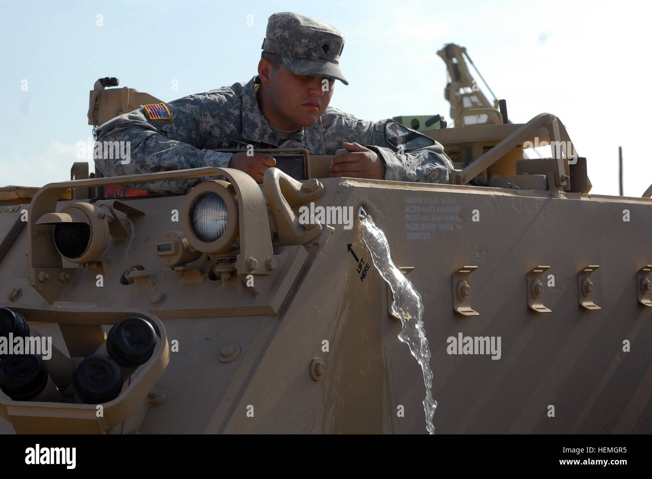 Spc. Fredericko Flores, a wheeled vehicle mechanic assigned to Headquarters and Headquarters Company, 1st Brigade Special Troops Battalion, 1st Brigade Combat Team, 1st Cavalry Division, drains excess water from the engine compartment of an M113 Armored Personnel Carrier using a bilge pump April 15 at Fort Hood, Texas. The excess water was found while conducting preventive maintenance checks and services. (Photo by Sgt. John Couffer, 1st BCT, 1st Cavalry Division Public Affairs) A soldier%%%%%%%%E2%%%%%%%%80%%%%%%%%99s passion, a vehicle%%%%%%%%E2%%%%%%%%80%%%%%%%%99s readiness 130415-A-EO505- Stock Photo