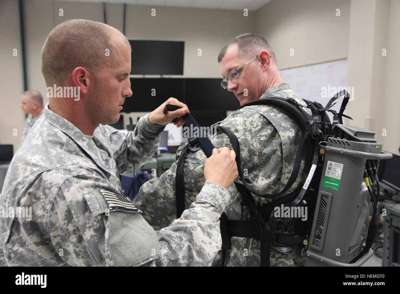 U.S. Army Staff Sgt. Christopher Isbelle (Left), assigned to Headquarters Troop, is assisting Spc. Robert Wrenn (Right) assigned to Lima Troop, 4th Joint Communication Support Element (Airborne)/ 4 Joint Communication Support, with attaching his arm sensors to his the virtual reality equipment at Mission Command Training Branch Building, Fort Stewart, Ga., April 16, 2013. This training is helping Soldiers operate using a virtual environment as if they were on a real life mission on a foreign battlefield. (U.S. Army photo by Sgt. Austin Berner/Not Released) Virtual reality training 130416-A-BZ5 Stock Photo