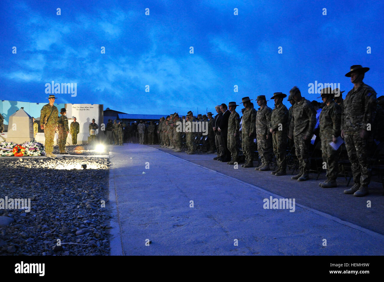 Australian troops, along with their coalition partners, bow their heads during the ANZAC Day dawn service at Multi-National Base Tarin Kot, Afghanistan, April 25, 2013. Australia and New Zealand Army Corps Day marks the beginning of the Battle of Gallipoli and is commemorated annually as a day of remembrance for those who made the ultimate sacrifice. (U.S. Army photo by Sgt. Jessi Ann McCormick) US troops participate in Australian Defence Force day of remembrance 130425-A-FS372-348 Stock Photo