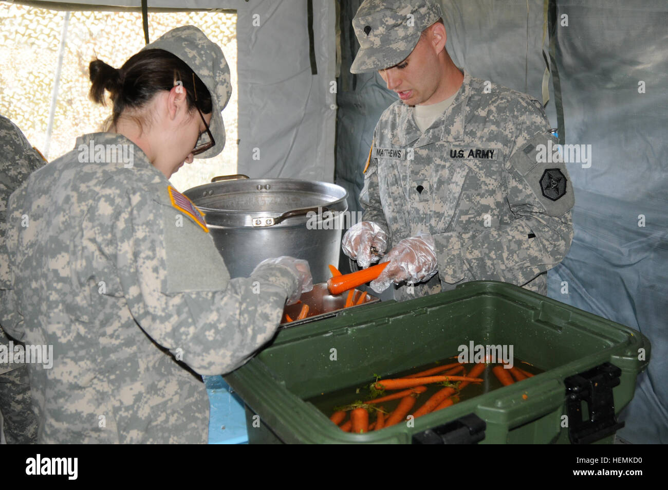 Pvt. Wendy Barraza, left, and Spc. Scott Matthews, food service specialists with the 737th Transportation Company, a U.S. Army Reserve unit here, peel carrots during the unit's Connelly Award competition meal, June 15, 2013. Peeling 130615-A-WJ570-145 Stock Photo