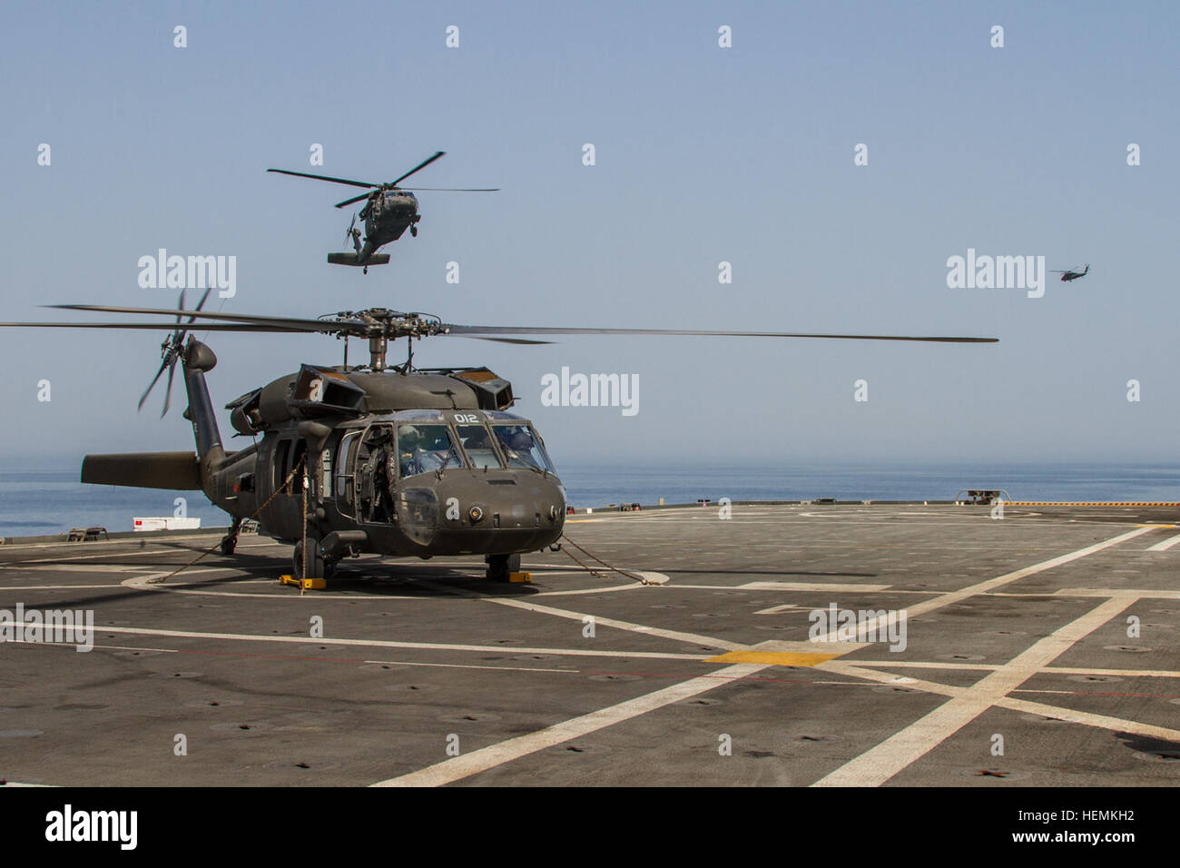 UH-60 Black Hawk helicopters from Alpha Company, 1-207th Aviation Regiment (Alaska Army National Guard) land on the flight deck of the USS Ponce AFSB(I)15 during training operations in the Persian Gulf. The company is currently deployed to the Middle East in support of Operation Enduring Freedom. (U.S. Army photo by Sgt. Mark Scovell/Released) Alaska soldiers navigate from desert to sea 062113-A-AY590-044 Stock Photo