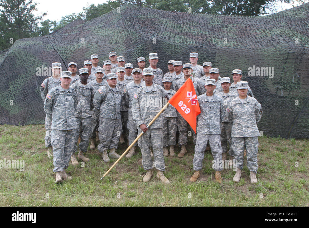 Soldiers from the 829th Signal Company, 303rd Maneuver Enhancement Brigade stand in front of the tactical camouflage netting they had just completed assembling July 14 at Fort McCoy, Wis. The 303rd MEB will be conducting a war exercise, Operation Compass Shield, there July 23-30. (U.S. Army Photo by Spc. David Harthcock) Soldiers of the 829th Signal Company at 2013 WAREX 130714-A-VH612-389 Stock Photo