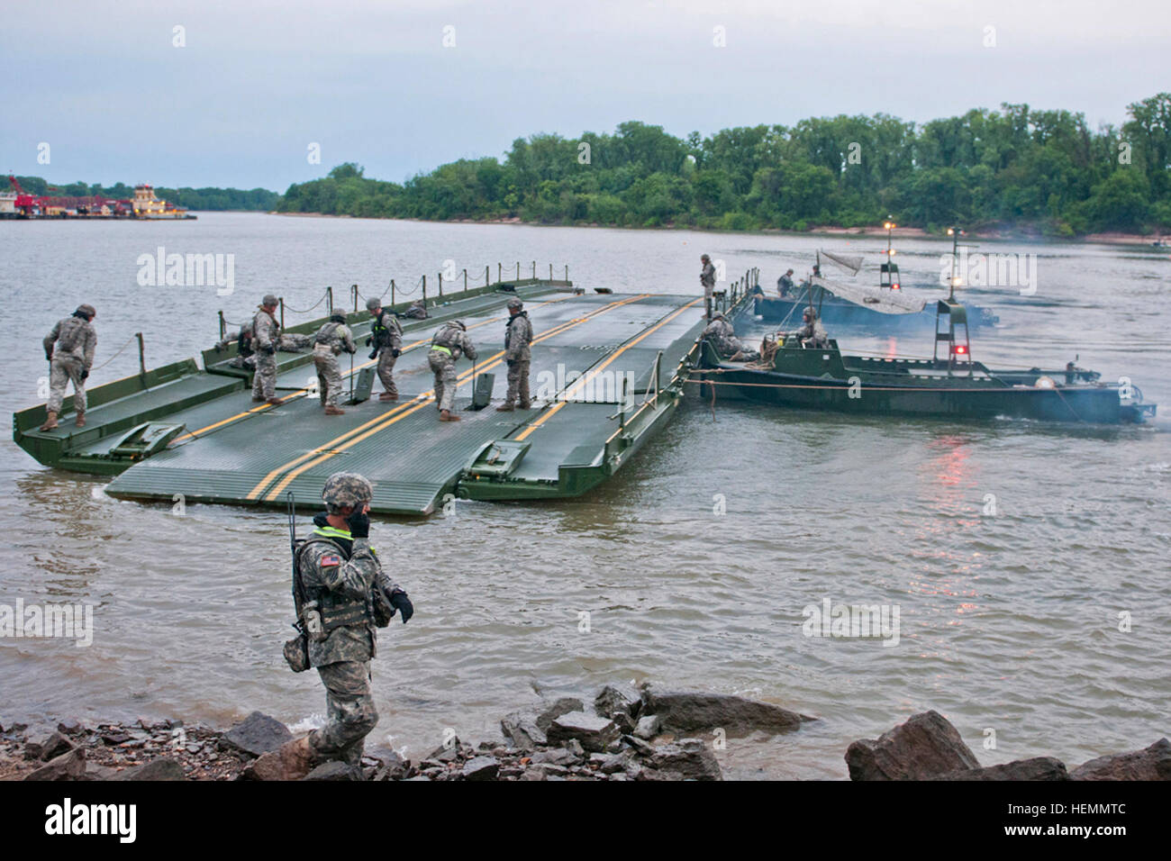 U.S. Army combat engineers with the 671st Engineer Company (Multi-Role Bridge), 74th Engineer Company (MRB) and 459th Engineer Company (MRB), merge bridge sections together to create a barge to transport vehicles across the Arkansas River during Operation River Assault at Fort Chaffee, Ark., July 24, 2013.  (U.S. Army photo by Sgt. Dalton Smith/Released) Operation River Assault 2013 130724-A-BG398-007 Stock Photo