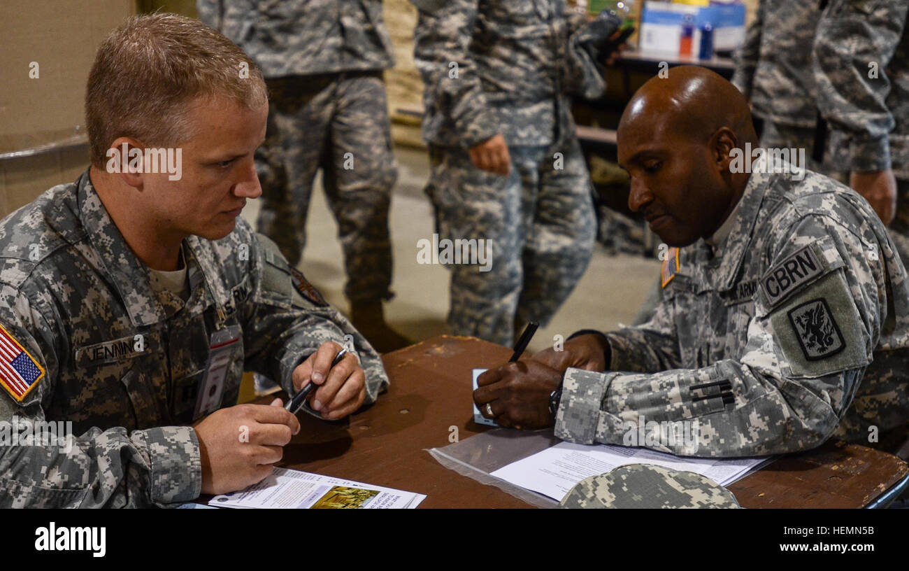U.S. Army Command Sgt. Maj., Elijah Moore, right, assigned to the 415th Chemical Brigade completes provider screening paperwork for Capt., David Jennings of 7217th Medical Support Unit, as part of the in-processing for exercise Vibrant Response 13-2 at Camp Atterbury, Ind., July 30, 2013. Vibrant Response is a U.S. Northern Command-sponsored field training exercise for chemical, biological, radiological, nuclear and high-yield explosive consequence management forces designed to improve their ability to respond to catastrophic incidents.  (U.S. Army photo by Staff Sgt. Taisha Lockhart/Released) Stock Photo