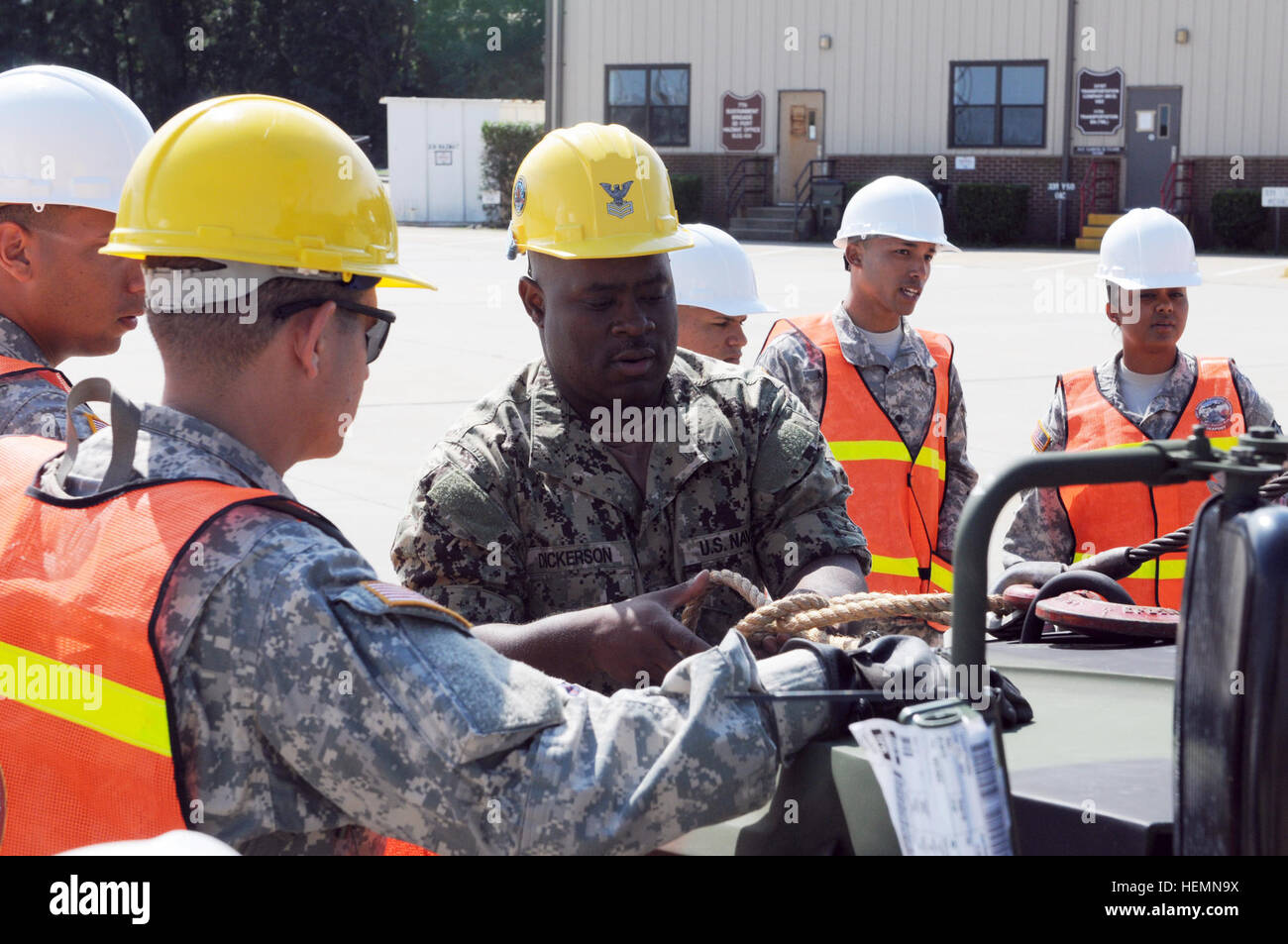 U.S. Navy Boatswain's Mate 1st Class Kevin Dickerson, center, helps