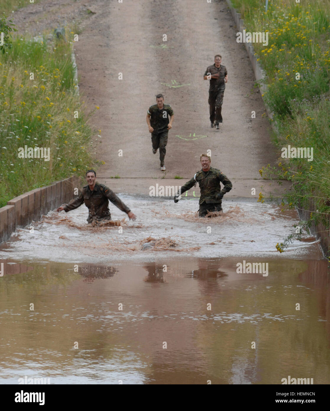 Soldiers of the Bundeswehr, German army negotiate a water obstacle during the Joint Multinational Friendship Competition Shock N' Rock Reloaded held Aug. 8, 2013 at Baumholder, Germany. (U.S. Army photo by Elisabeth Paque/Released) Shock N' Rock Competition 2013 130808-A-PB921-004 Stock Photo