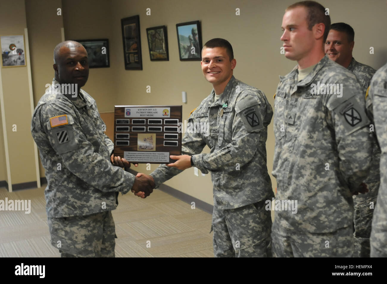 Col. Timothy U. Philips, Commander, 4th Brigade, 10th Mountain Division, Provisional, presents Pfc. Nicholas Solomon, Headquarters Company, 2nd Battalion, 4th Infantry Regiment, 4th Brigade, 10th Mountain Division, with a plaque for winning the Patriot Brigade's Best Medic Competition held at Brigade Headquarters Building on Sept 11. The Patriot Brigade's Best Medic Competition 130909-A-CB167-203 Stock Photo