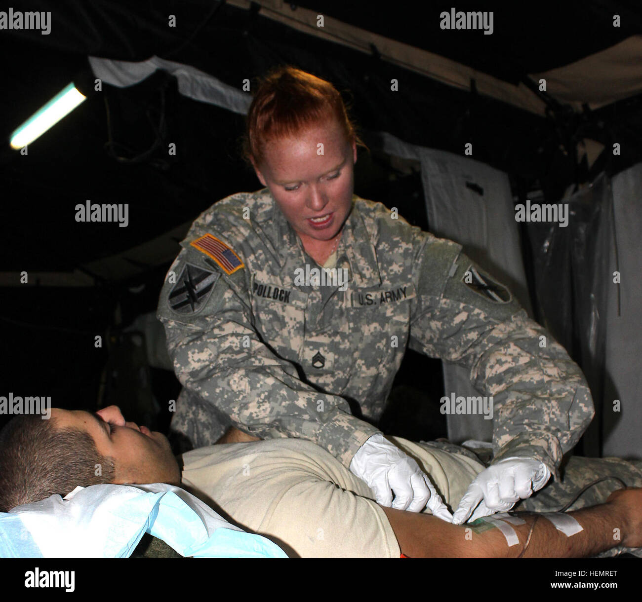 As the medical readiness noncommissioned officer in charge, Staff Sgt. Rebecca Pollock talks her heat casualty patient through an intravenous therapy to correct electrolyte imbalances. Nine female Georgia Guardsmen have been selected to integrate into combat related positions that were formerly all male. Pollock, a combat medic, will be one of those chosen to join the ranks of the 48th Infantry Brigade Combat Team line companies. The 48th IBCT is one of nine Army National Guard infantry brigades to receive the authorization for assigning women to their maneuver battalions. 'I know a lot of the Stock Photo