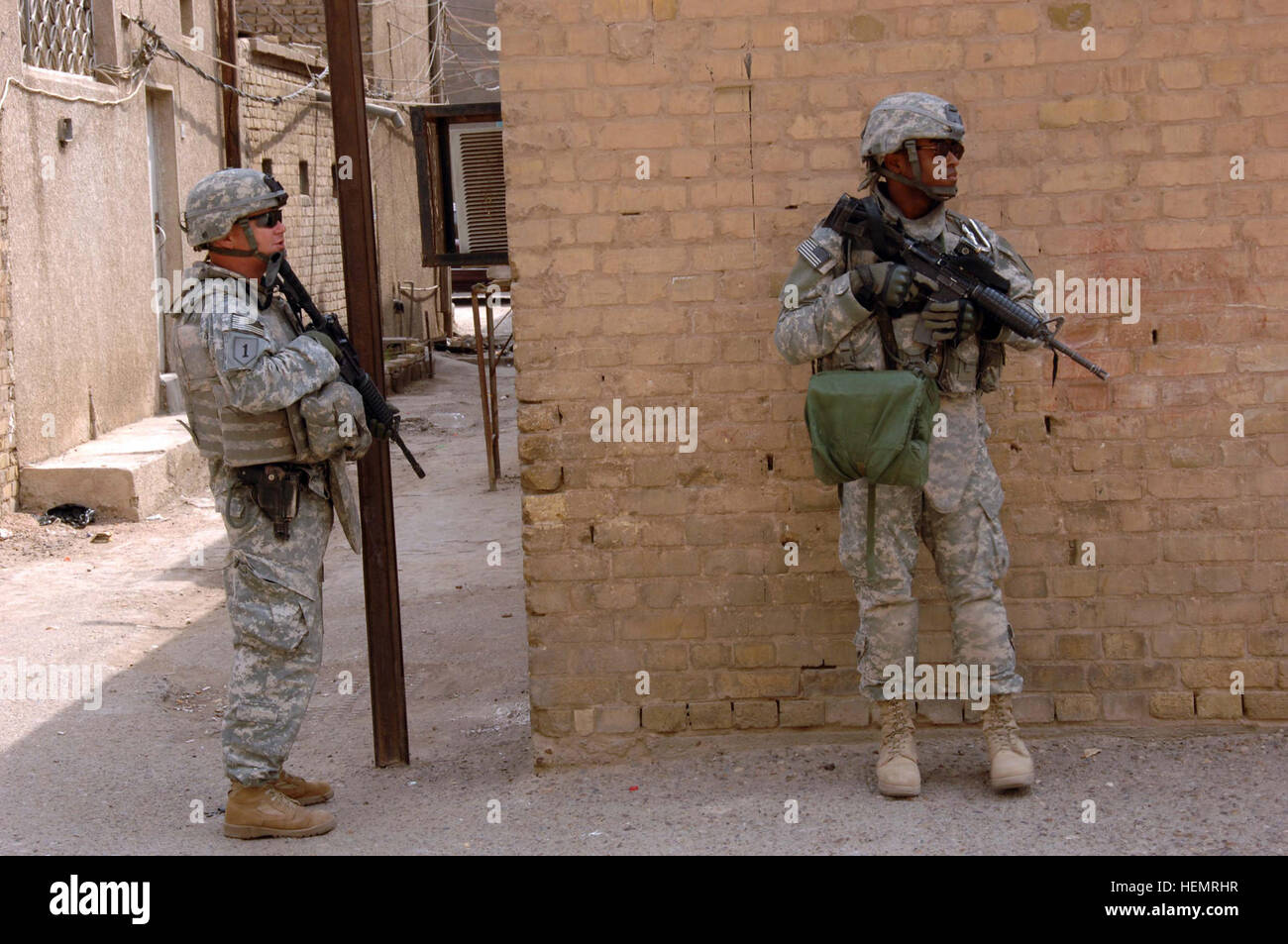 U.S. Army Sgt 1st Class Donald Bryan and U.S. Army Pfc. Jon Pierre Johnson, of 1st Armored Division, 2nd Stryker Cavalry Regiment, 4th Squadron Quick strike Troop, pull security outside during a meeting at a police station in the Muhaila neighborhood of Baghdad, Iraq, on Oct. 1. The visit was part of an ongoing validation of Iraqi police in the neighborhood. Validation of Iraqi police 62348 Stock Photo