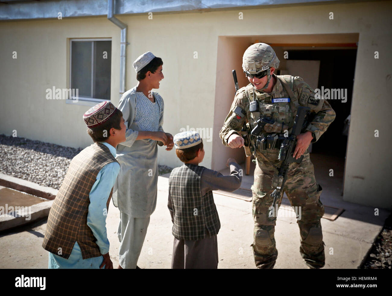 Sgt. Jeffrey Nelan, a Infantryman with the 184th Security Force Assistance Team, California National Guard, plays with Afghan children during a leadership engagement at the Afghan Uniformed Police headquarters in Uruzgan Province, Afghanistan, Sept. 25, 2013. (U.S. Army photo by Cpl. Harold Flynn Leadership Engagement Security 130925-A-XQ077-779 Stock Photo
