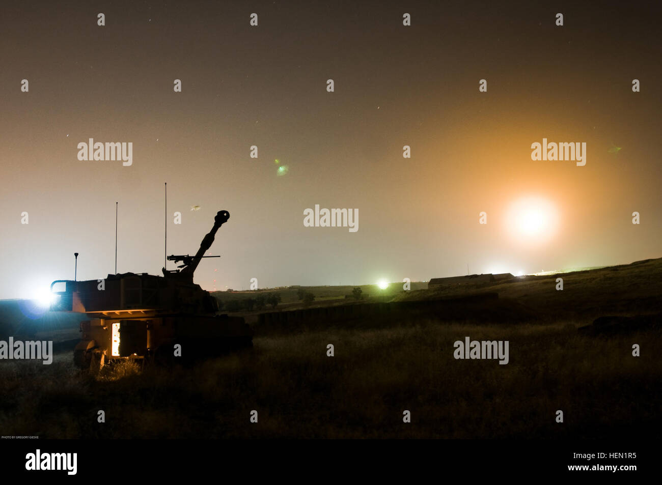 Moments after blasting a Howitzer round from 1st Battalion, 9th Field Artillery, 2nd Heavy Brigade Combat Team, 3rd Infantry Division's Canon Artillery System, an illumination flare is seen falling towards the earth over Contingency Operating Site Marez and Diamondback, Mosul, Iraq, May 8. Battle Kings Night Fire 278475 Stock Photo