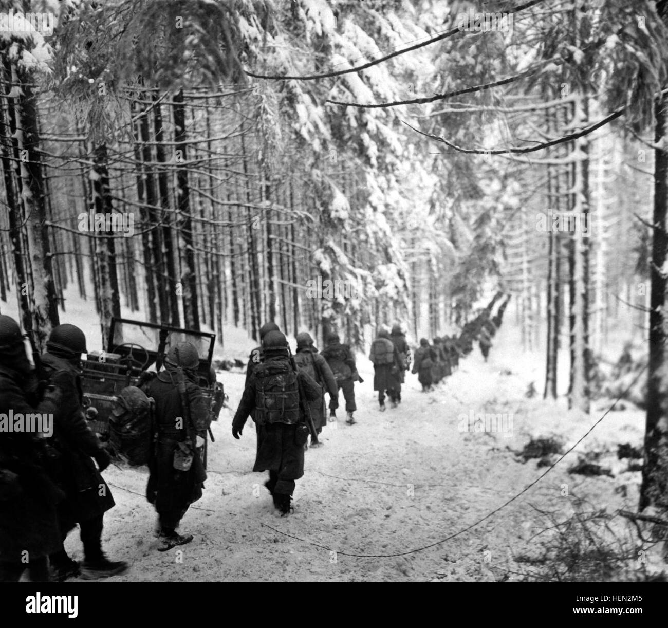 American soldiers of the 289th Infantry Regiment march along the snow-covered road on their way to cut off the St. Vith-Houffalize road in Belgium.  January 24, 1945.  Richard A. Massenge.  (Army) NARA FILE #:  111-SC-199406 WAR & CONFLICT BOOK #:  1079 Bulge stvithroad 1945jan24 375 Stock Photo