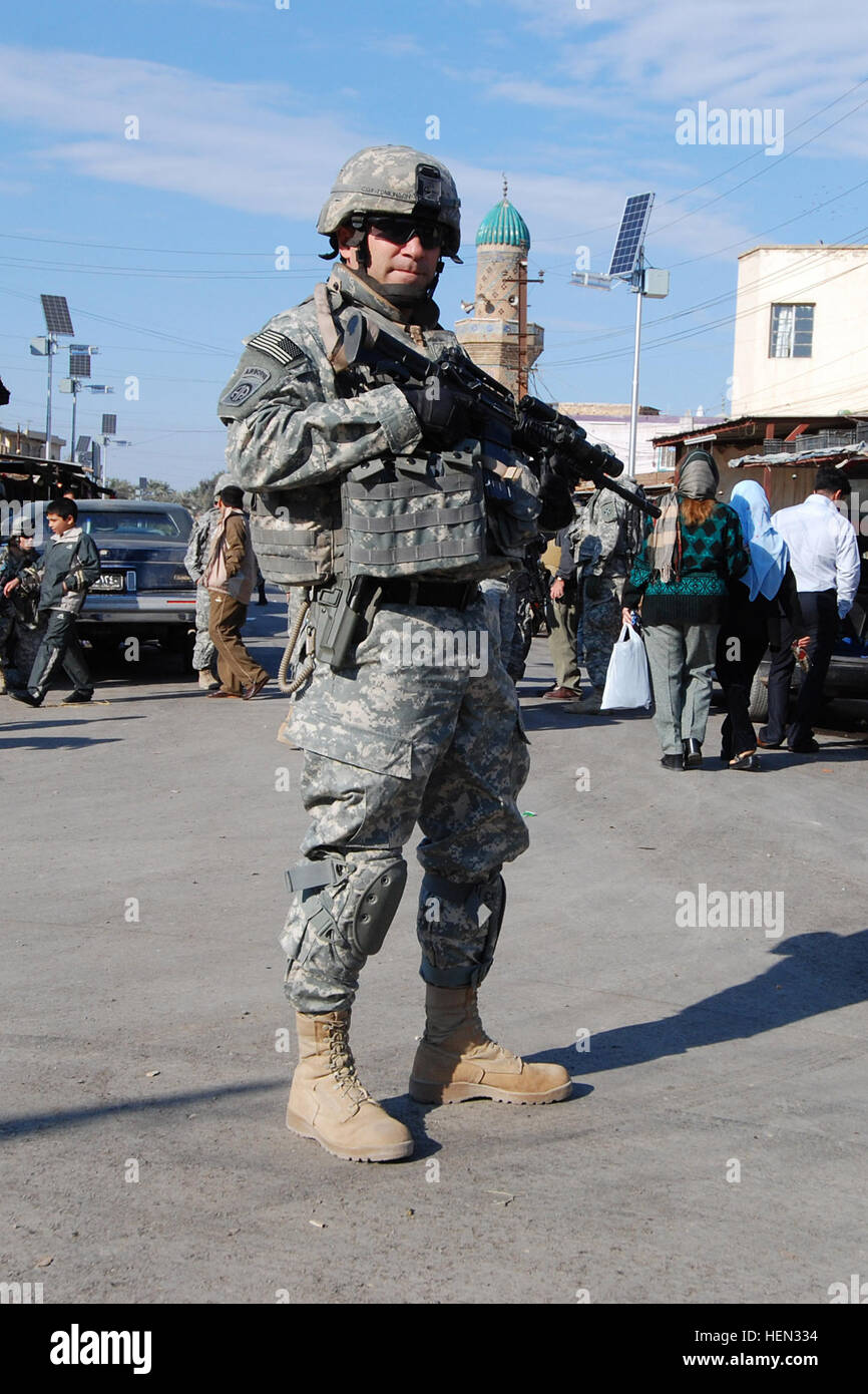 McAllister, Okla., native, Command Sgt. Maj. Jim Tomlinson, the senior non-commissioned officer for the 2nd Battalion, 319th Airborne Field Artillery Regiment, 2nd Brigade Combat Team, 82nd Airborne Division, provides security for his men during a patrol through a market area in the Rabi neighborhood of northeast Baghdad, Dec. 19. Sergeant Major's got you covered 70302 Stock Photo