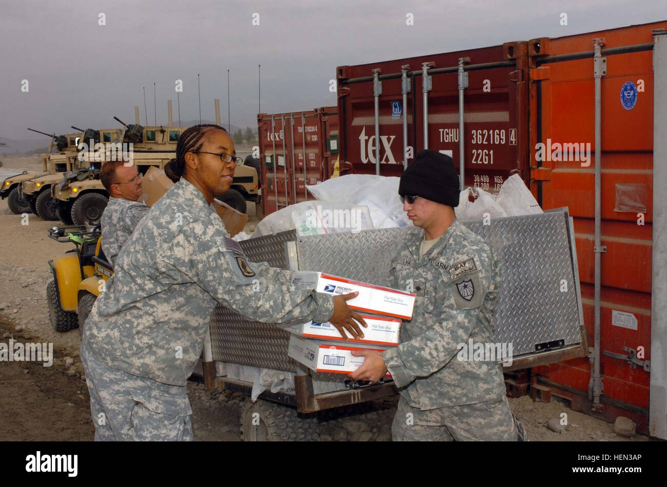 071220-A-4619A-072:  Army Sgt. Brian R. Boss (rear), 42, from Valliant, Okla., Spc. Jose L. Silva (right), 20, from Garland, Texas, both of 458th AG Postal Company, and Spc. Tanya M. Runnels, 34, from Jasper, Texas, with Headquarters and Headquarters Company, 173rd Brigade Support Battalion (Airborne) load outgoing mail to a pallet to be loaded on a plane for a flight back to the United States Dec. 20 at FOB Fenty in Afghanistan. Christmas Brings Tons of Mail to TF Bayonet 70271 Stock Photo