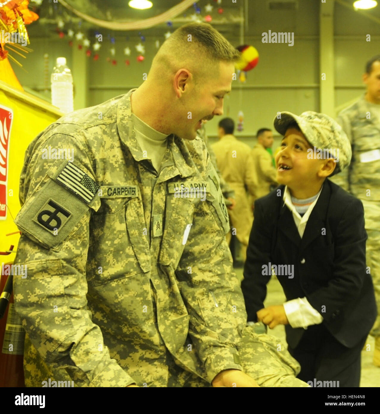 Sgt. Matthew Carpenter, a chaplain assistant for the 90th Sustainment Brigade, 13th Sustainment Command (Expeditionary) and a Portales, N.M., native, shares a laugh with Zakaria, a child at Iraqi Kid's Day, Nov. 21, at Joint Base Balad, Iraq. Carpenter was Zakaria's mentor at an all day event that focused on children's hygiene. Iraqi children learn about personal hygiene at JBB 227455 Stock Photo