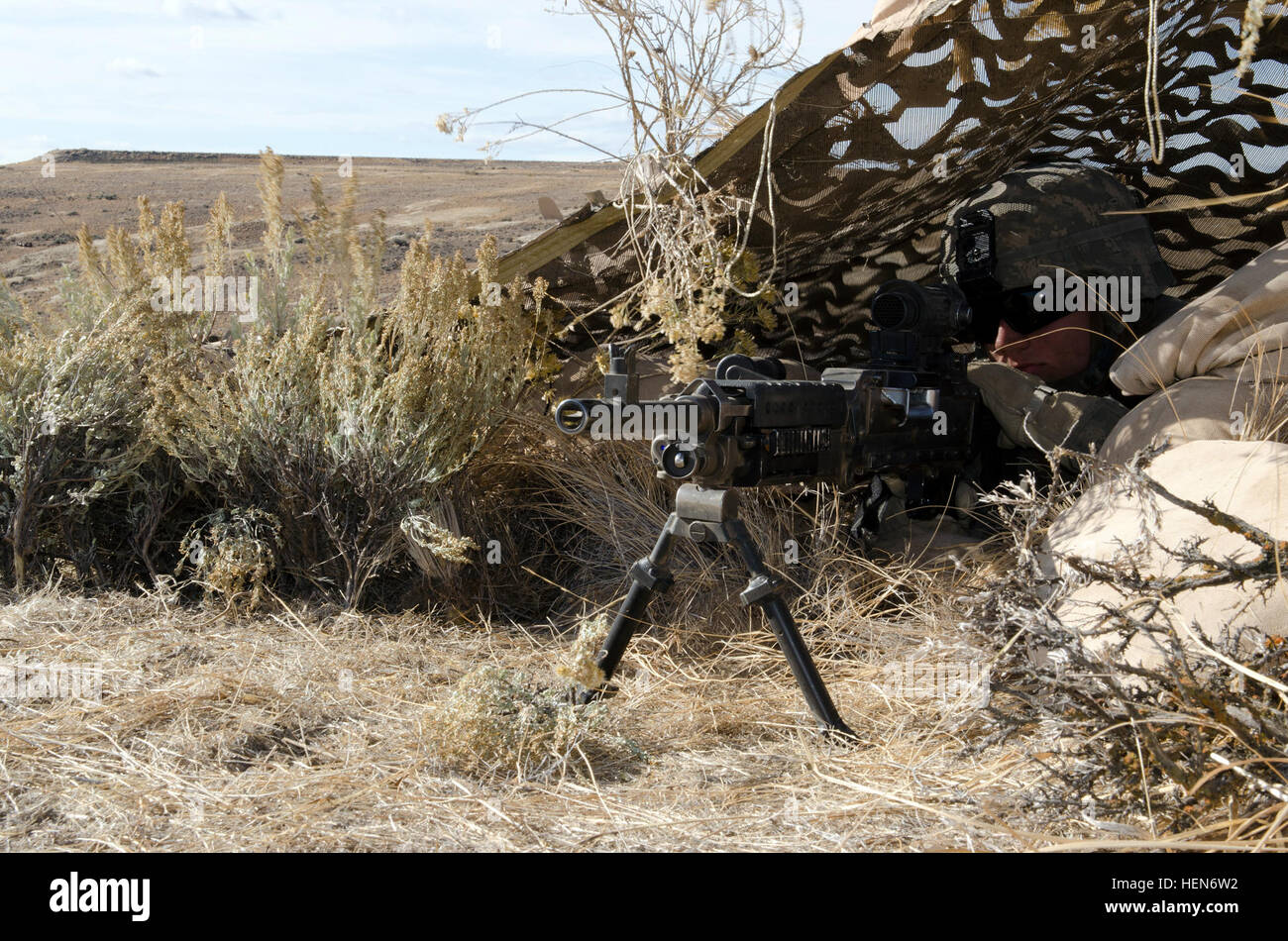 A U.S. Army soldier camouflages a defensive fighting position during ...