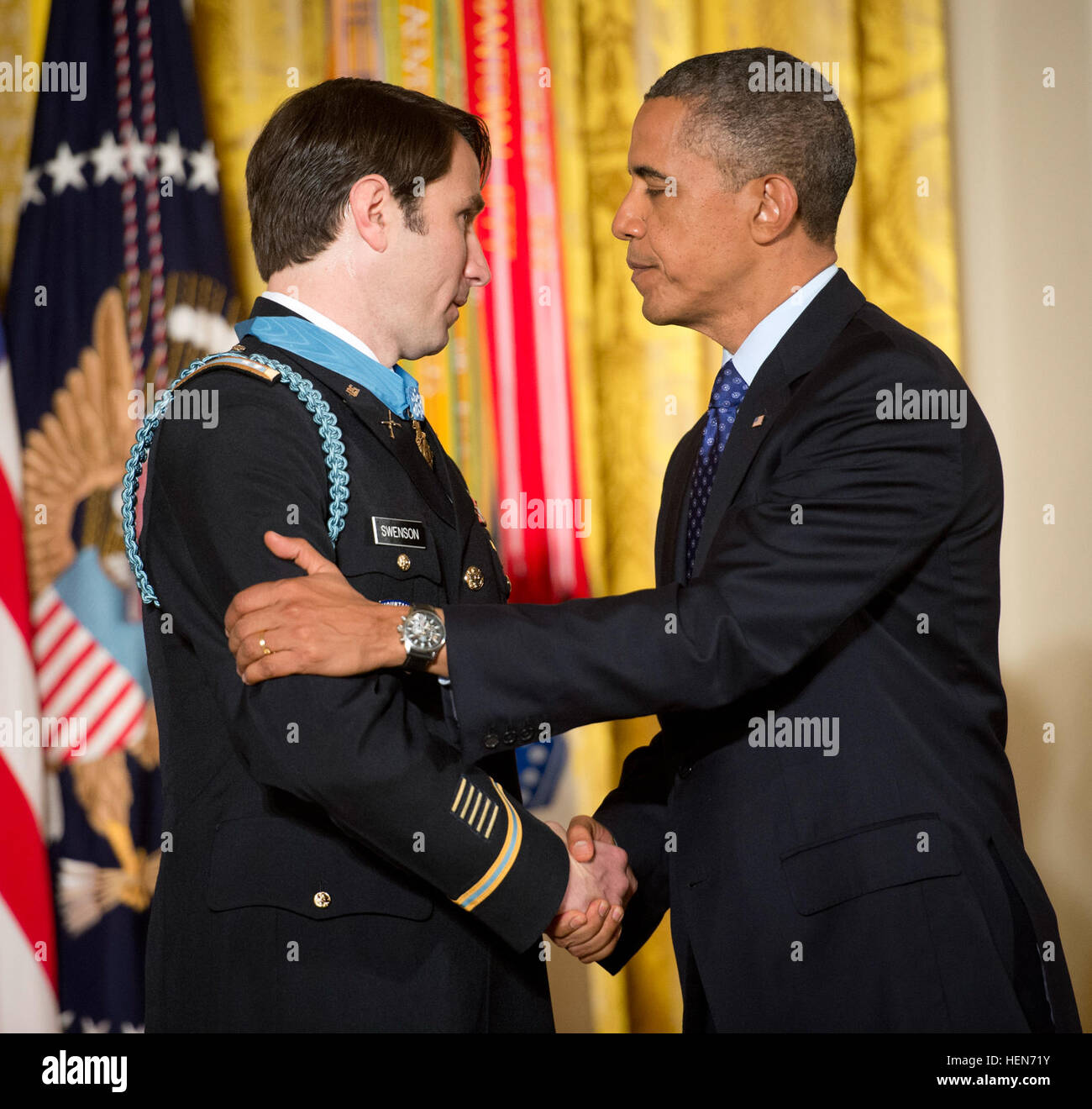 President Barack Obama congratulates former Capt. William D. Swenson just after he presented him with the Medal of Honor in the East Room of the White House, Oct. 15, 2013.  In six hours of continuous fighting against more than 60 well-armed, well-positioned enemy fighters, Swenson braved intense enemy fire and willfully put his life in danger against the enemy's main effort, multiple times in service of his fallen and wounded comrades while serving as an Afghan Border Police adviser, in support of 1st Battalion, 32nd Infantry Regiment, 3rd Brigade Combat Team, 10th Mountain Division (Light In Stock Photo