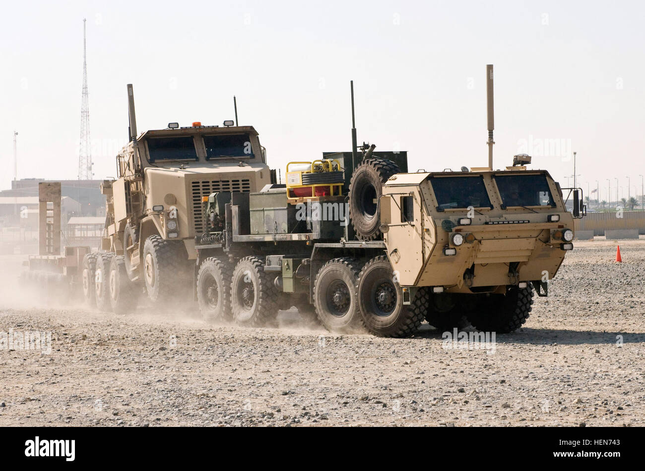 A Heavy Expanded Mobility Tactical Truck Wrecker tows a Heavy Equipment Transporter and trailer during a training exercise at Camp Arifjan, Kuwait. The trucks and the Soldiers who drive them make frequent trips into Iraq, retrieving equipment such as humvees, tanks and Mine Resistant Ambush Protected vehicles. (Photo by Monte Swift) Third Army's mission 258174 Stock Photo